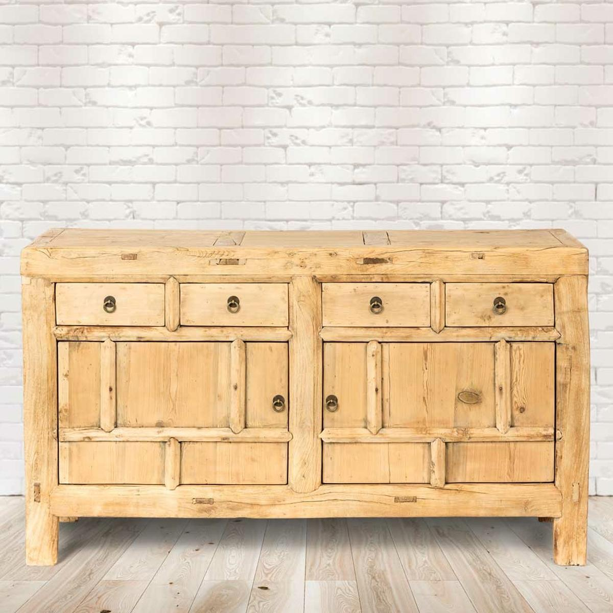 Holzschrank mit Schubladen und Türen. Helle Holzfarbe und weiße Ziegelwand.