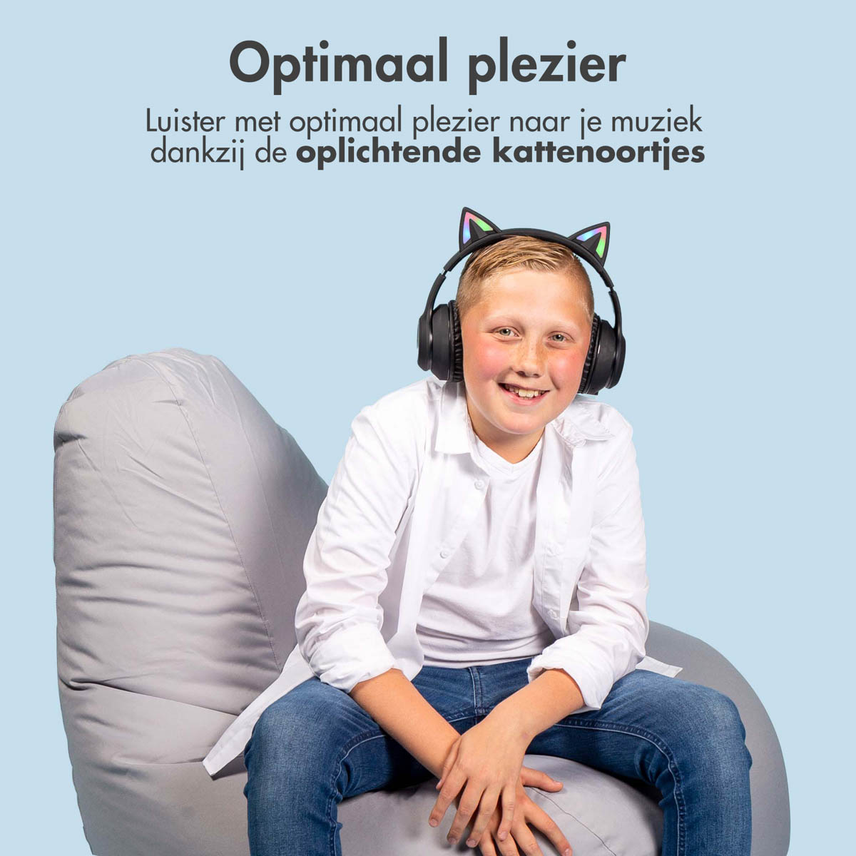 Een jongen met een koptelefoon met kattenoren, glimlachend.