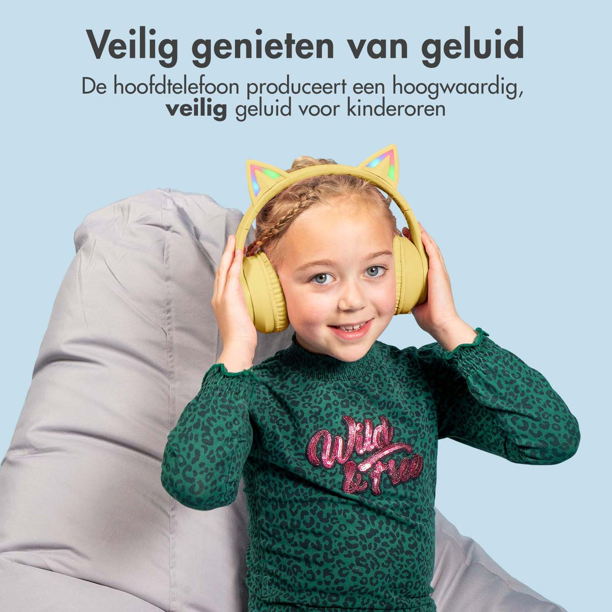 Meisje met een gele koptelefoon met kattenoren. Ze lacht. Grijze zitzak.