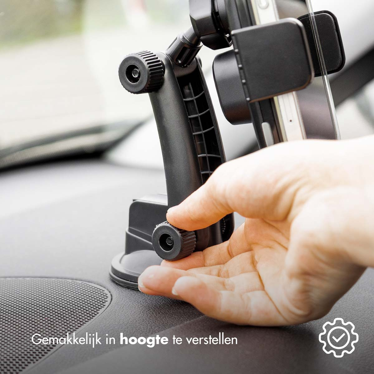 A hand adjusting a black phone holder on a dashboard.
