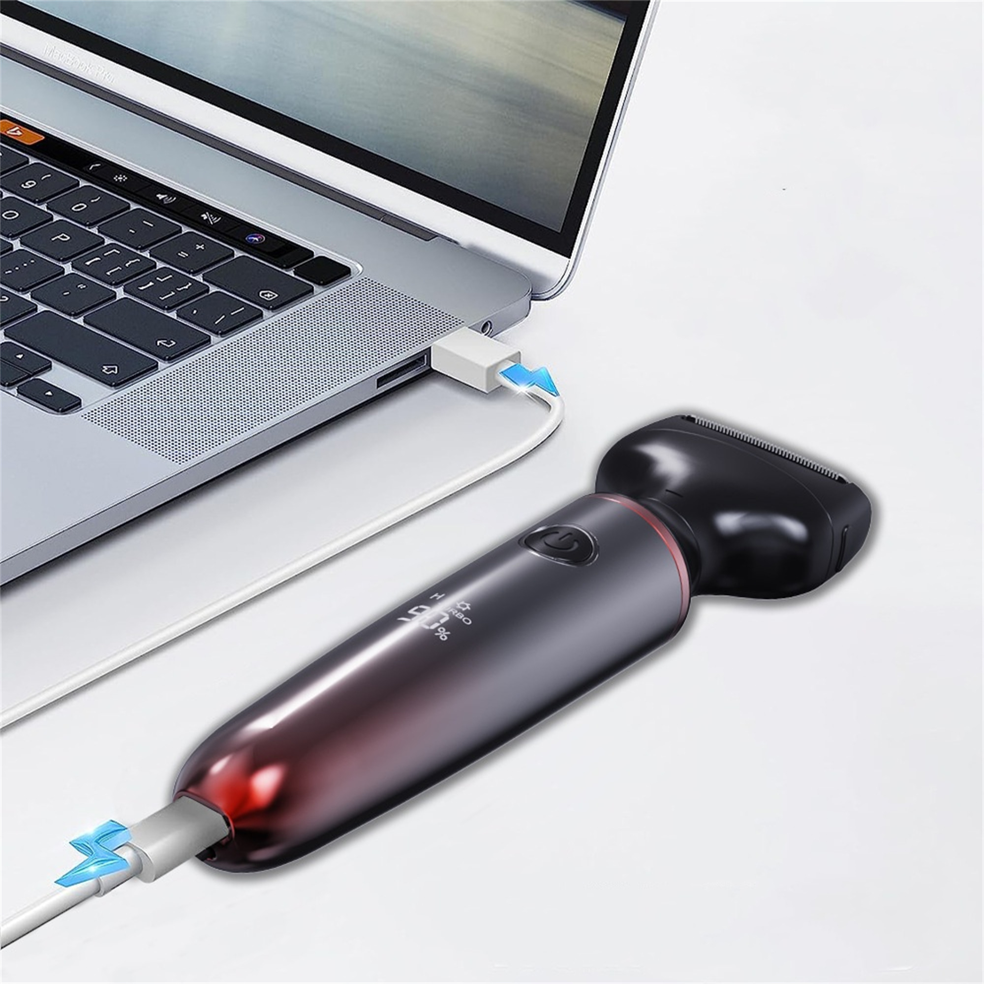 Laptop mit Rasierer verbunden. Rasierer wird über USB geladen. Beide auf weißer Oberfläche.