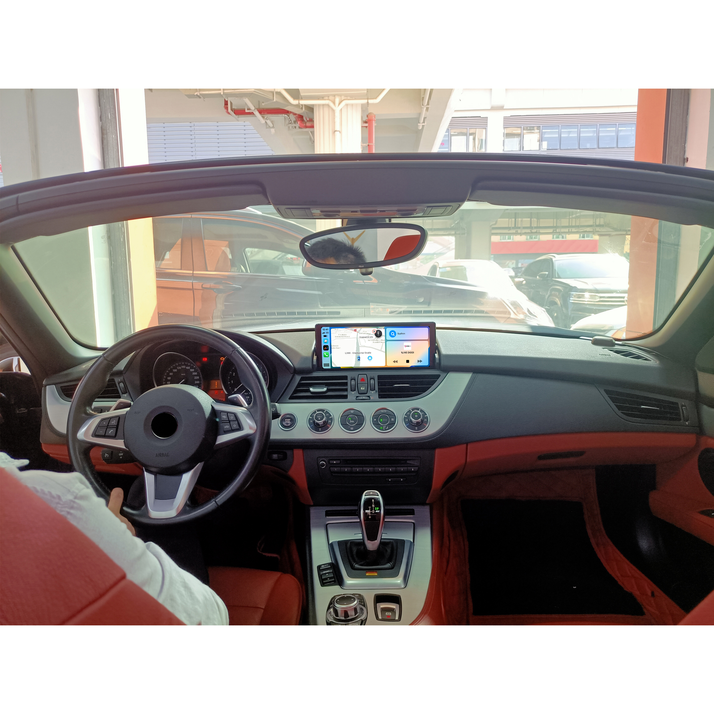 Innenraum eines Autos mit Armaturenbrett und Lenkrad. Ein Navigationsbildschirm befindet sich auf dem Armaturenbrett.