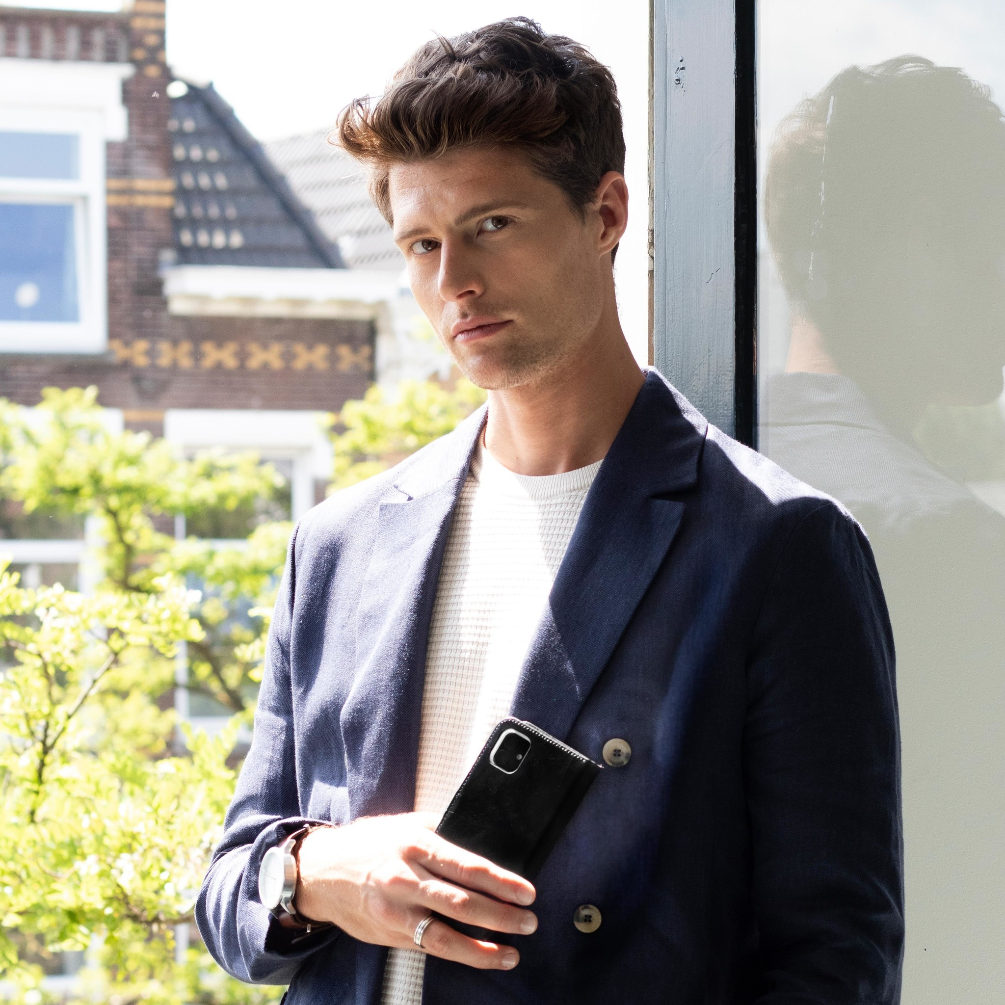 Un homme en costume tenant une coque de téléphone noire.