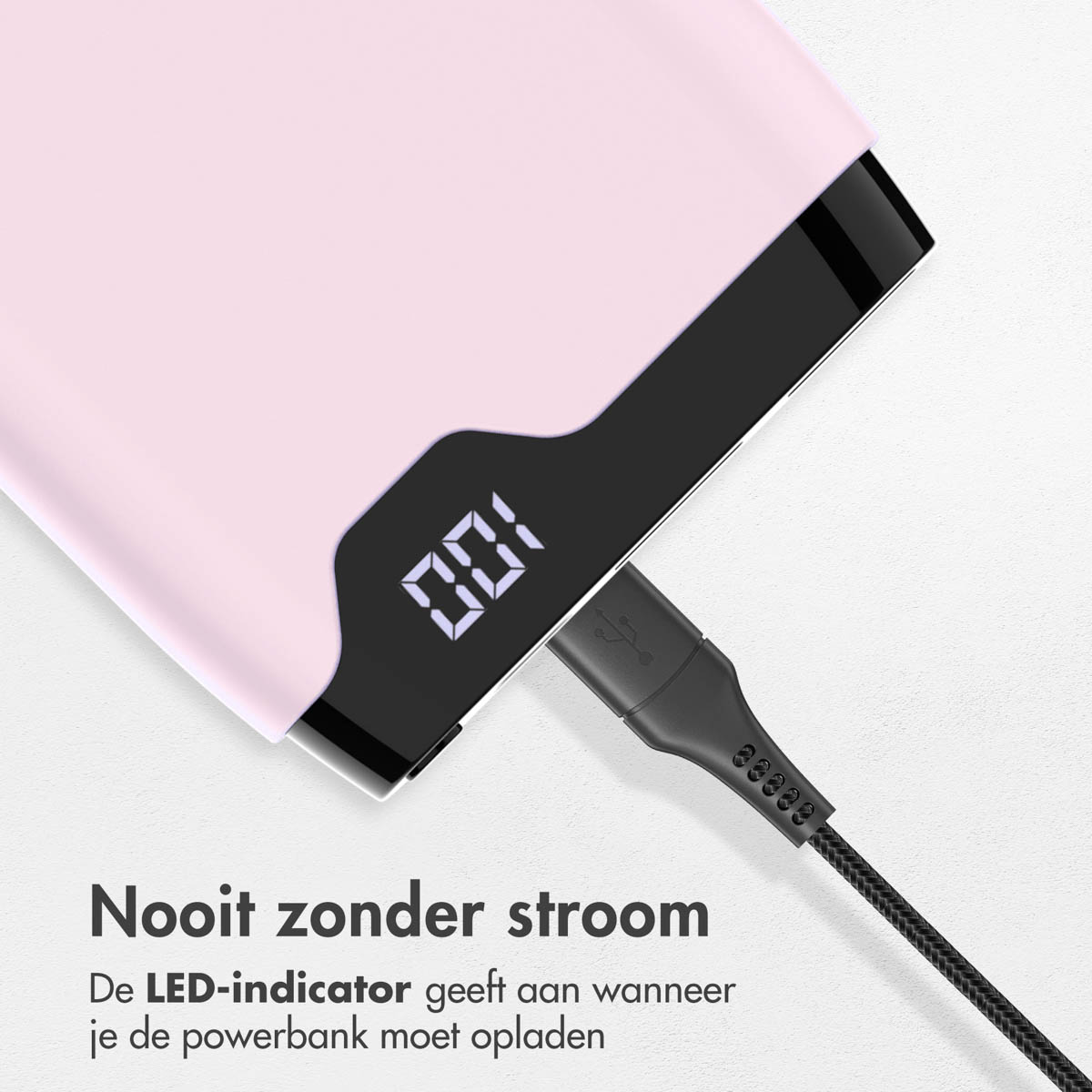 Power bank rose avec un câble USB-C branché. L'écran affiche 100% de charge.