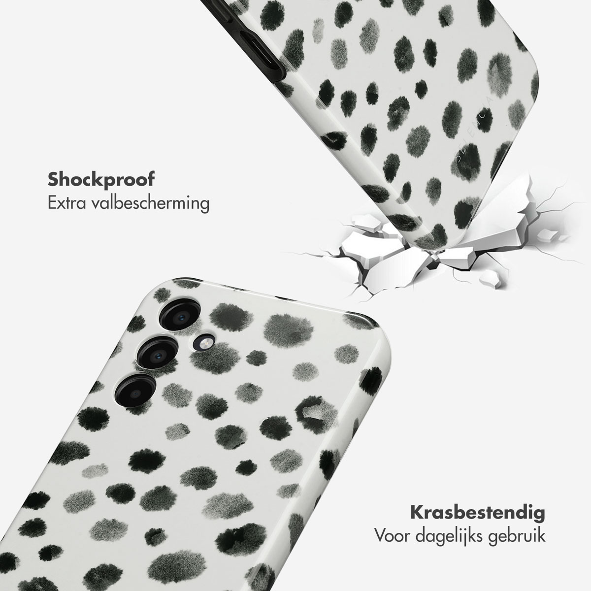 Twee witte telefoonhoesjes met zwarte stippen. Eén valt en de andere ligt op de grond.