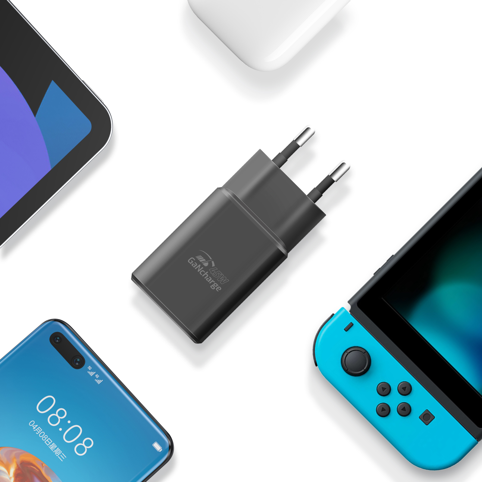 Caricabatterie con più dispositivi attorno: un tablet, un telefono e una console di gioco. Tutto su bianco.