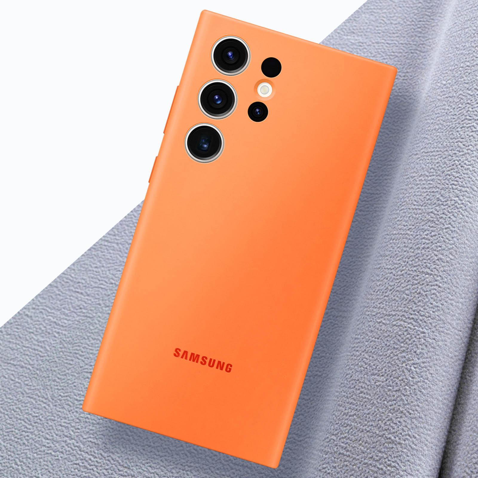 Orangene Handyhülle auf grauem Stoff, schräge Ansicht, mit Samsung-Logo.