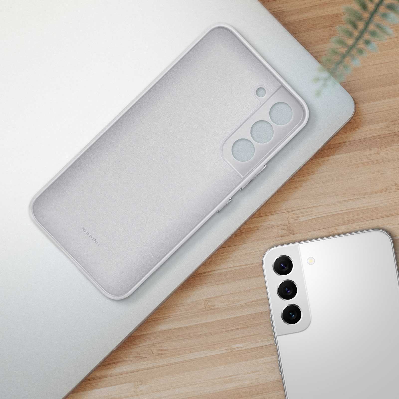 Una funda blanca para teléfono en una superficie, con un teléfono y su cámara visibles.