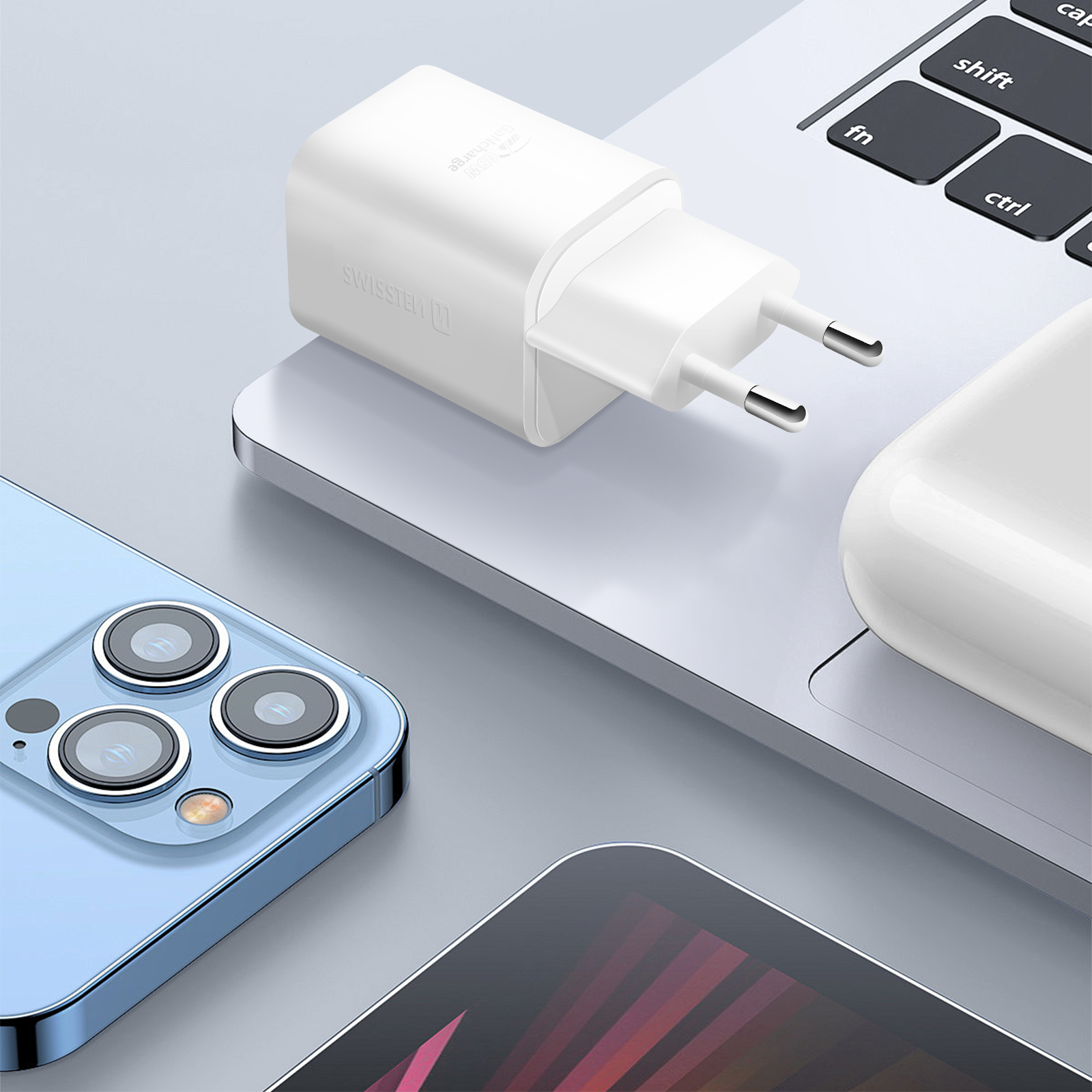Un caricabatterie bianco per telefono collegato a un laptop con un telefono nelle vicinanze.