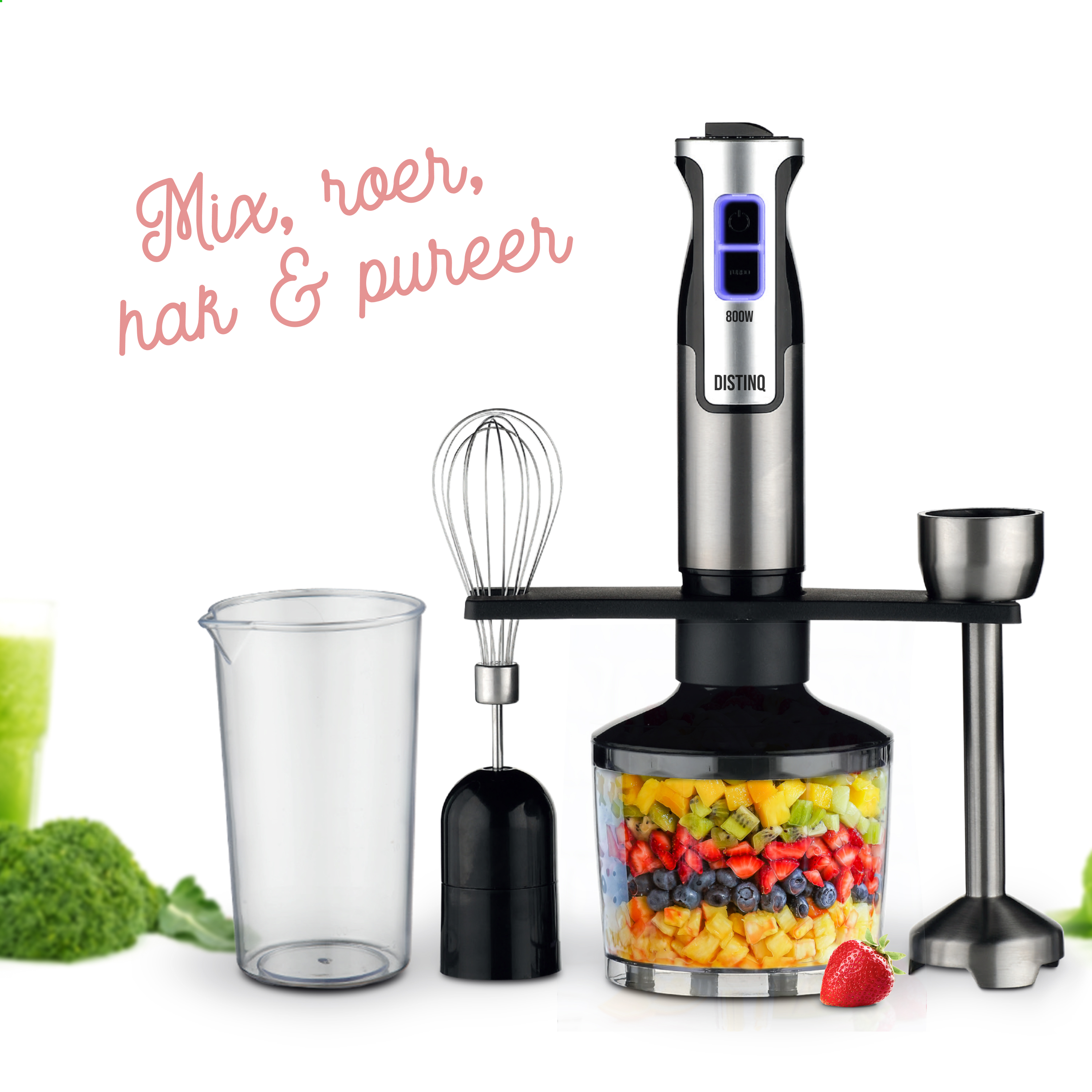 A blender with multiple attachments. It has a clear container with fruits and vegetables inside.