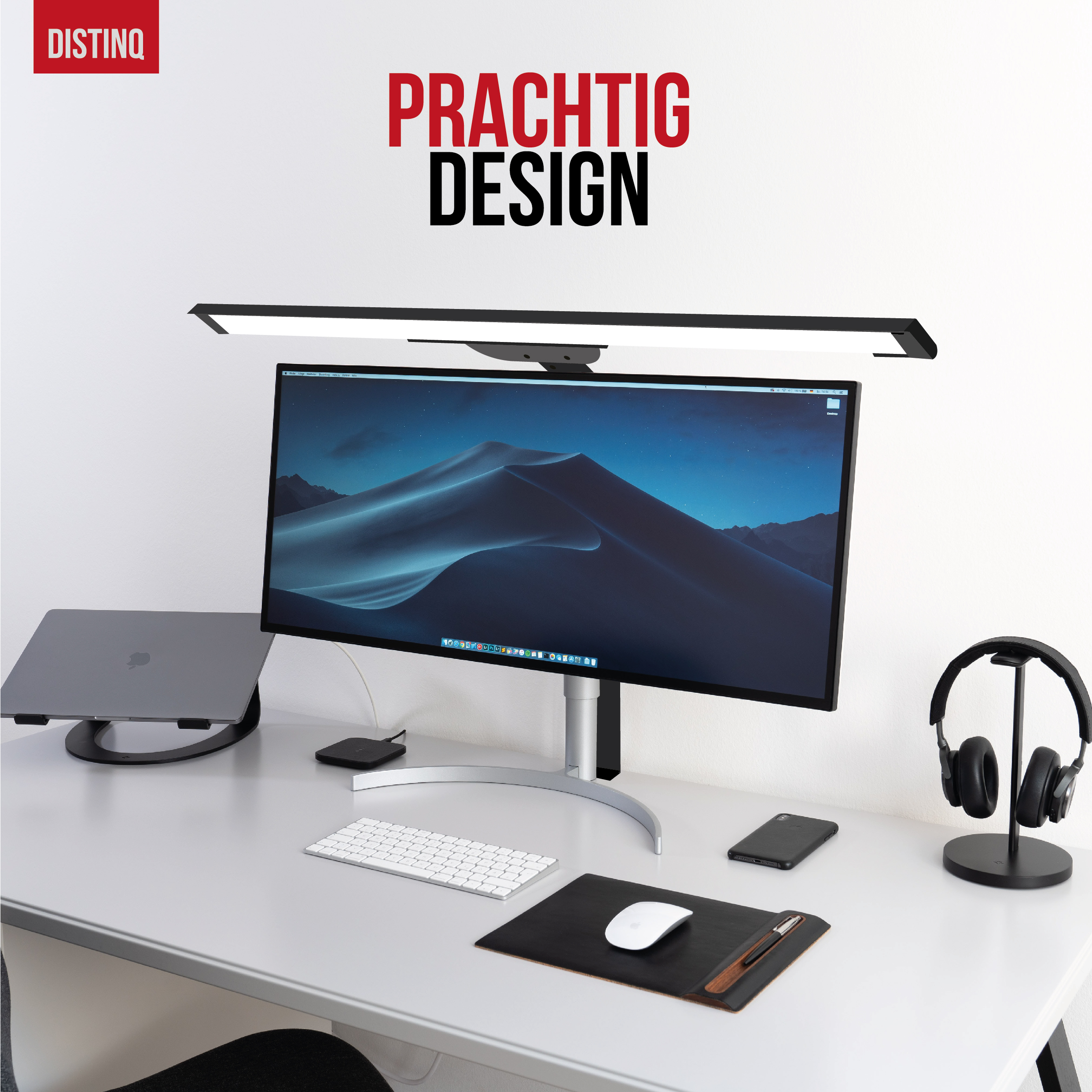 Bureau met monitor, lamp, laptop, toetsenbord, muis, telefoon en koptelefoon.