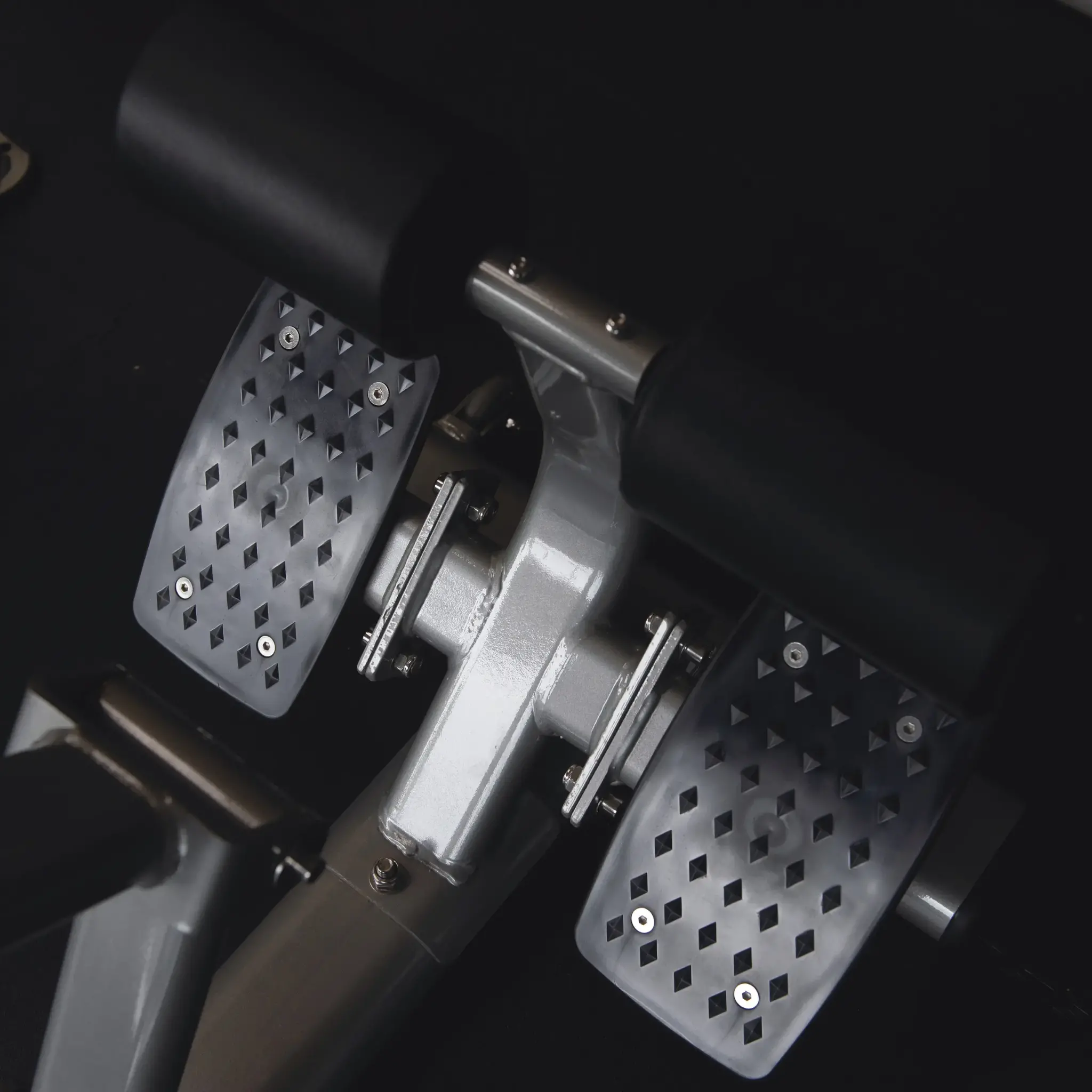 Close-up van een zwarte voetsteun van een gewichthefmachine. Antislip oppervlak met een patroon.
