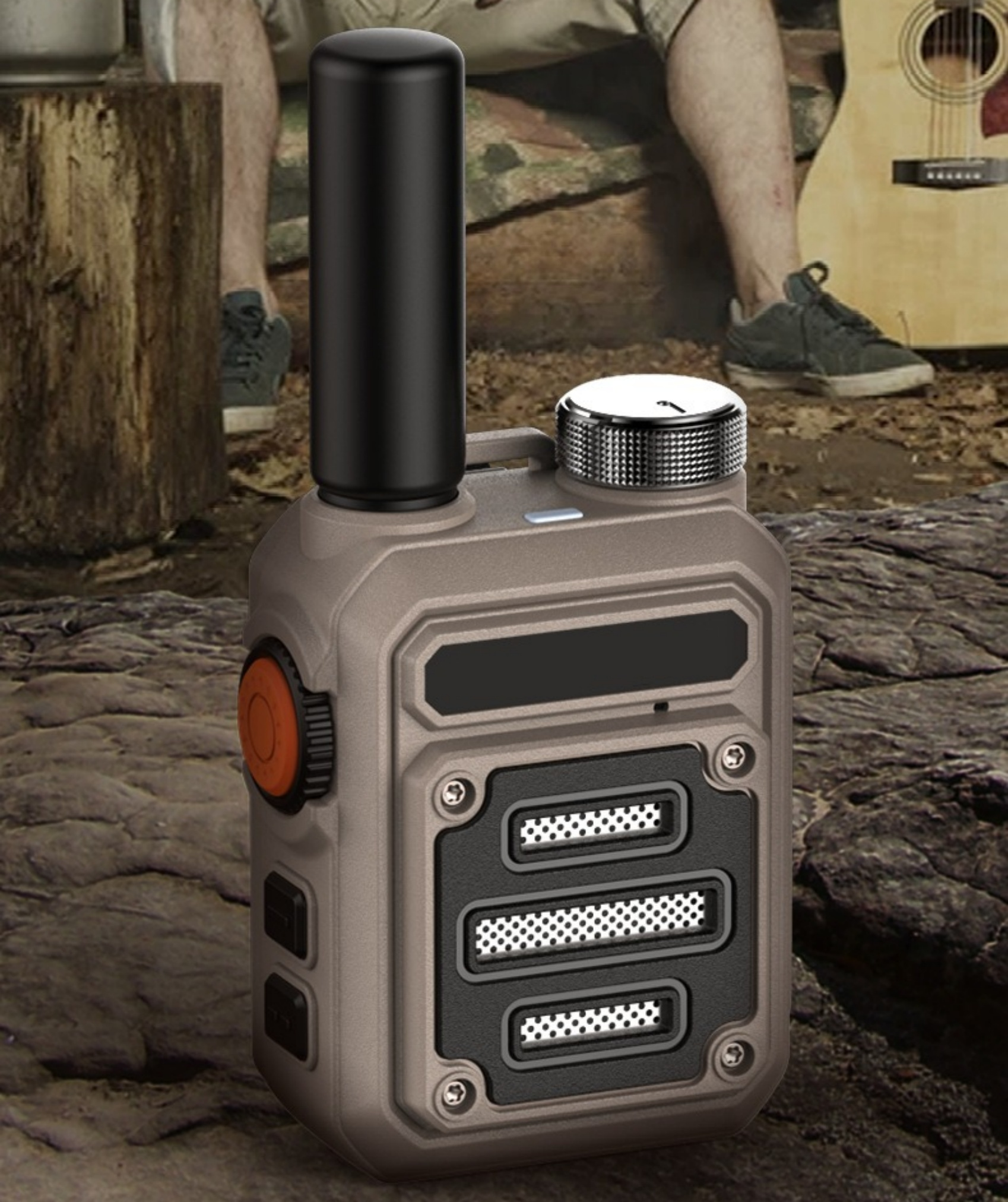 Ein Funkgerät auf einem Felsen. Im Hintergrund sitzt eine Person mit einer Gitarre.