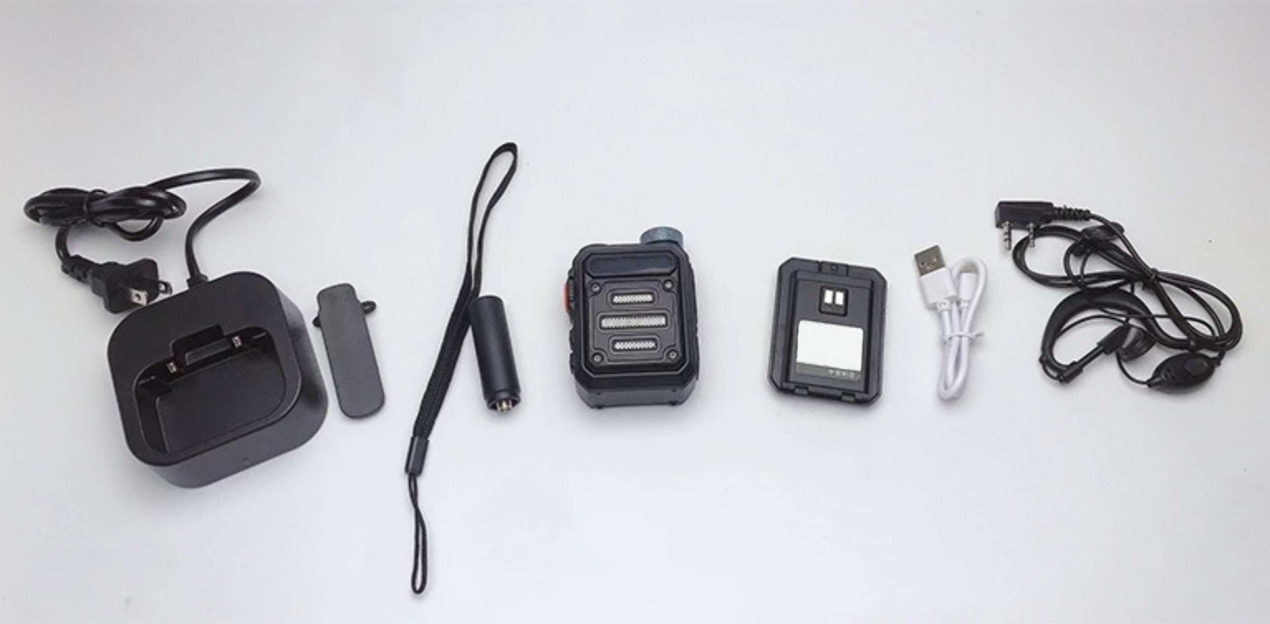Ein Set Walkie-Talkie-Zubehör, einschließlich Ladestation, Gürtelclip und Headset.