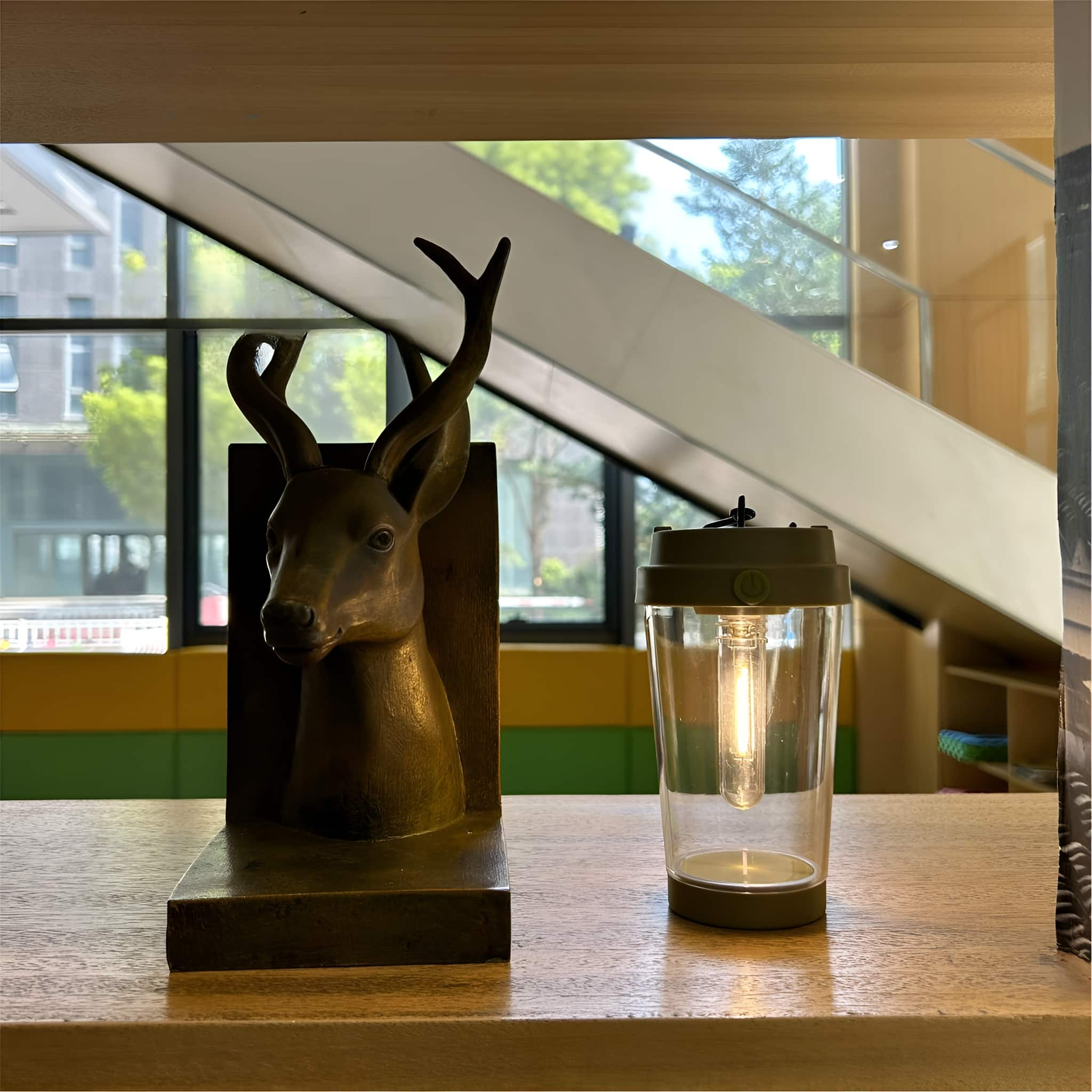 Eine dekorative Hirschkopfskulptur und eine Laterne auf Holz.