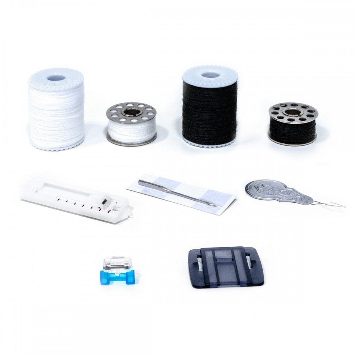 Suministros de costura: carretes de hilo blanco y negro, bobinas, aguja y otros accesorios.