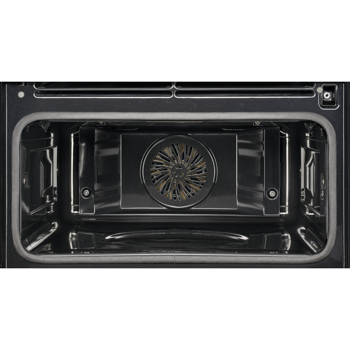 Interior de un horno con ventilador e iluminación interior, tomado desde adentro.