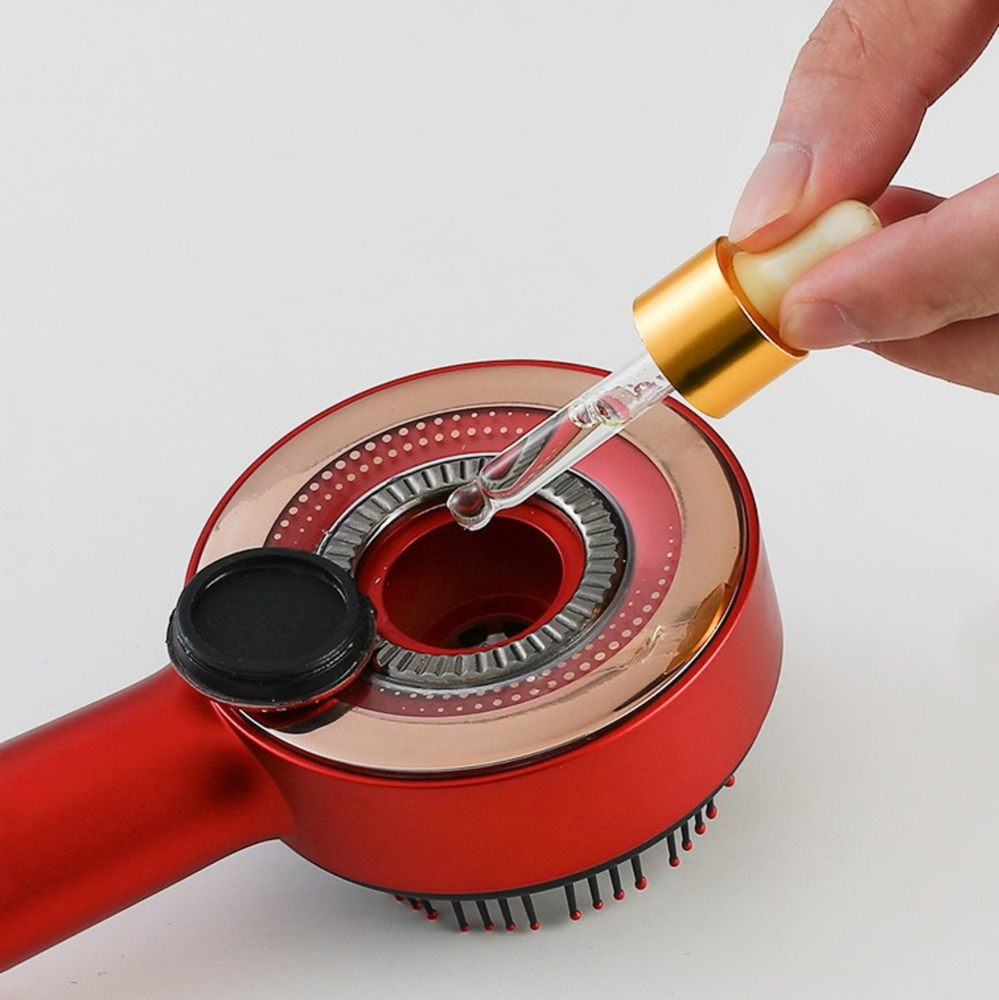 Rotes Schönheitsgerät mit einer Pipette, die Flüssigkeit abgibt. Eine Hand hält die Pipette.