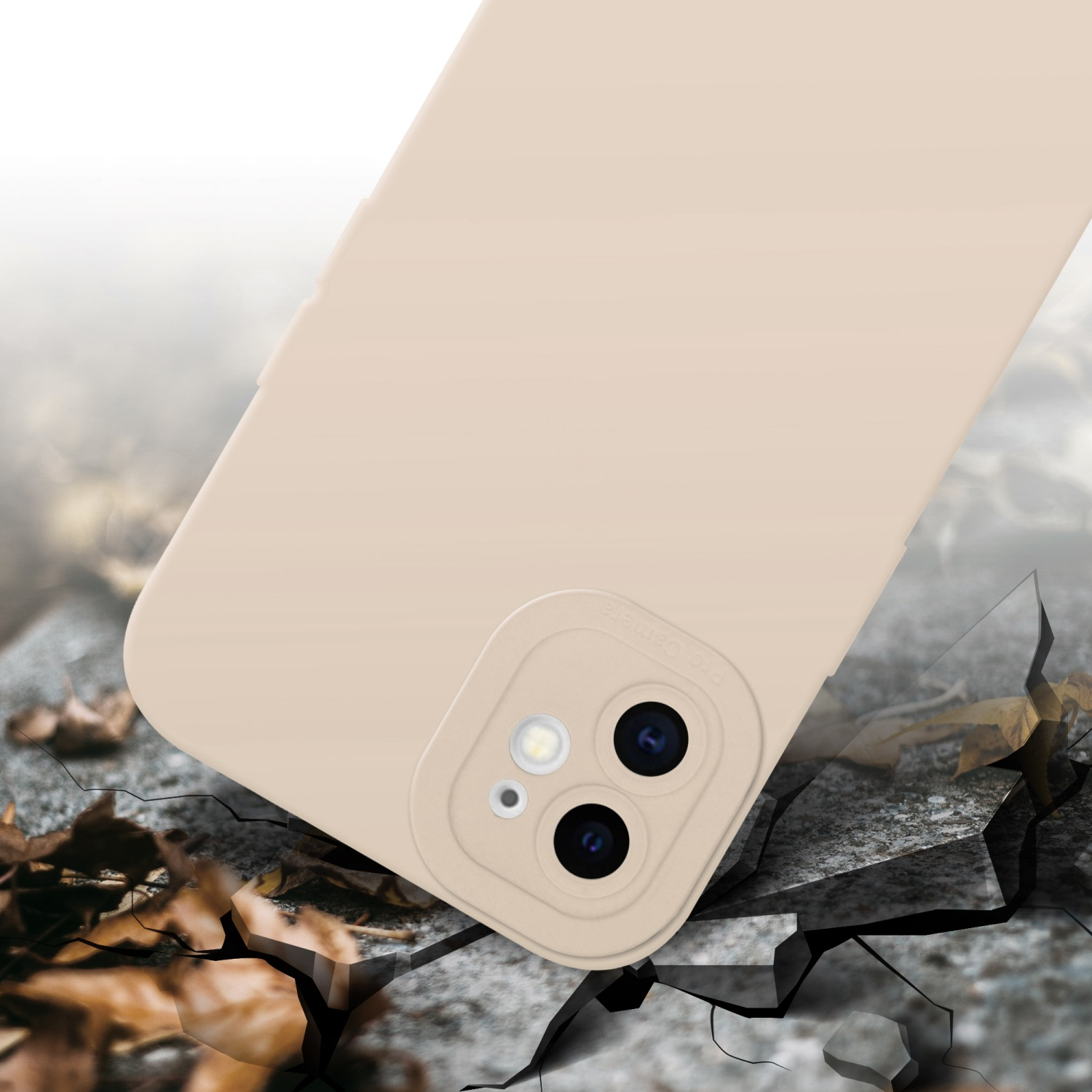 Una custodia beige per telefono con due obiettivi, su una superficie screpolata con foglie e detriti. Il telefono è angolato.