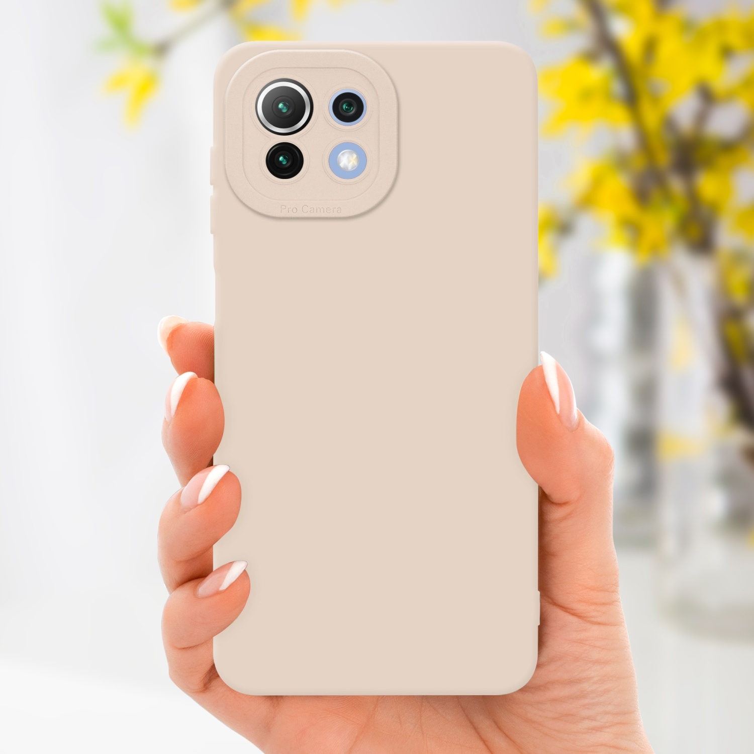 Une main tenant une coque de téléphone beige avec un appareil photo. Le fond a des fleurs jaunes.
