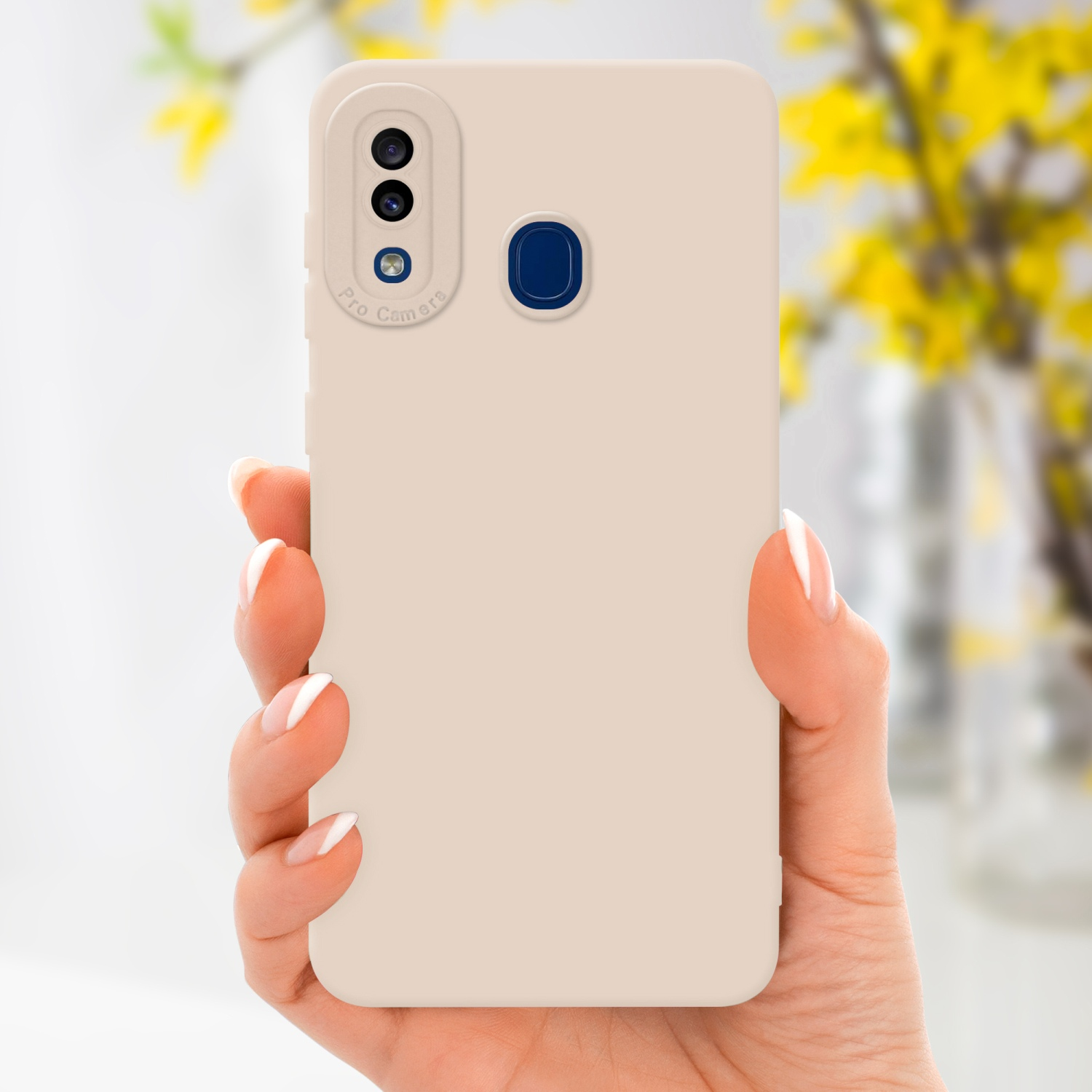 Una mano che tiene una custodia beige con tripla fotocamera su sfondo bianco.