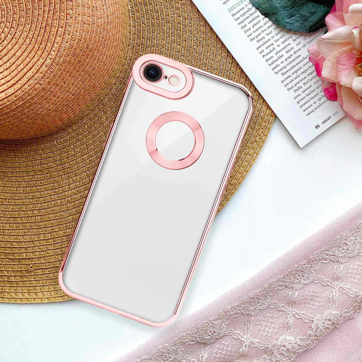 Ein Telefon in einer transparenten Hülle mit pinkfarbenem Rahmen, auf einem Strohhut liegend.