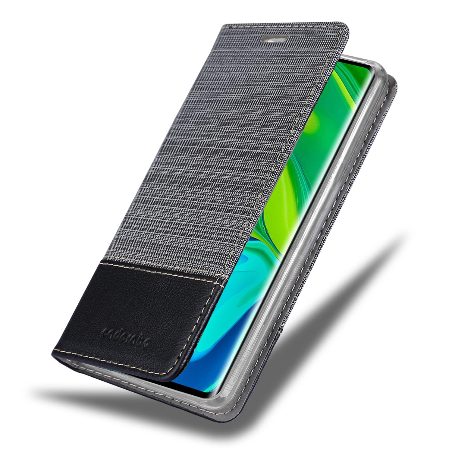 Ein Telefon befindet sich in einer grau-schwarzen Hülle. Die Hülle ist geöffnet und zeigt einen grün-blauen Telefonbildschirm.