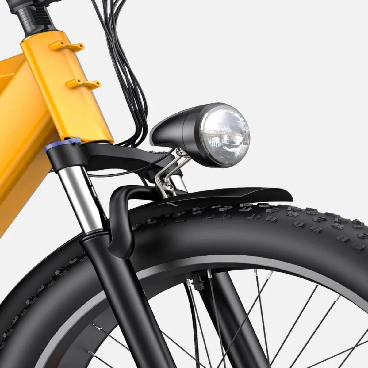 Primo piano del faro e dello pneumatico anteriore di una bicicletta elettrica, su sfondo bianco.