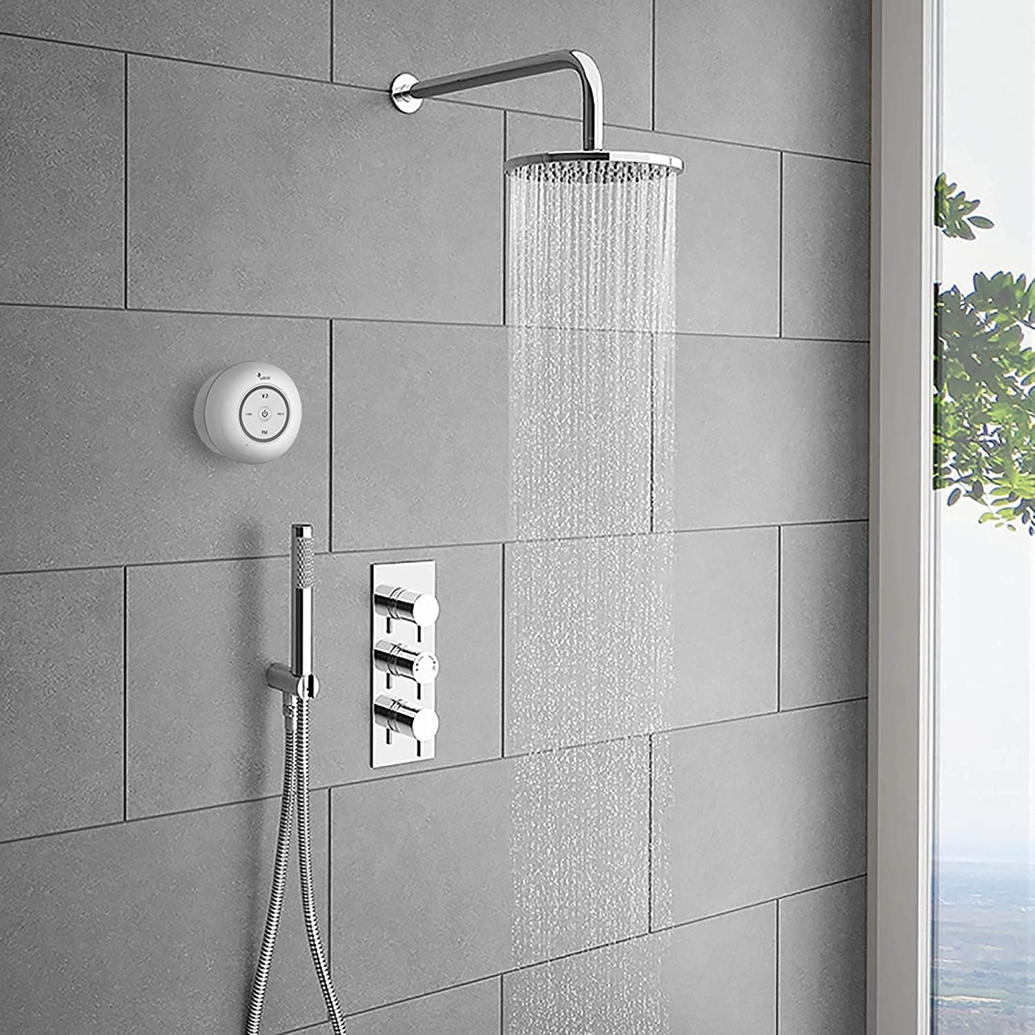 Eine Dusche mit Regenduschkopf und Handbrause. Die Wand ist mit grauen Fliesen bedeckt.