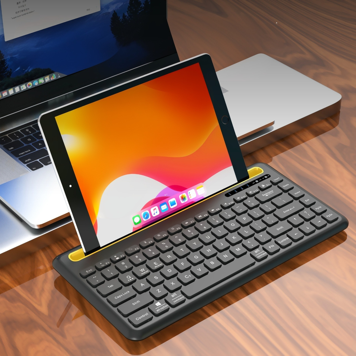 Tablet in Tastaturhülle, auf Tisch, Laptop im Hintergrund.