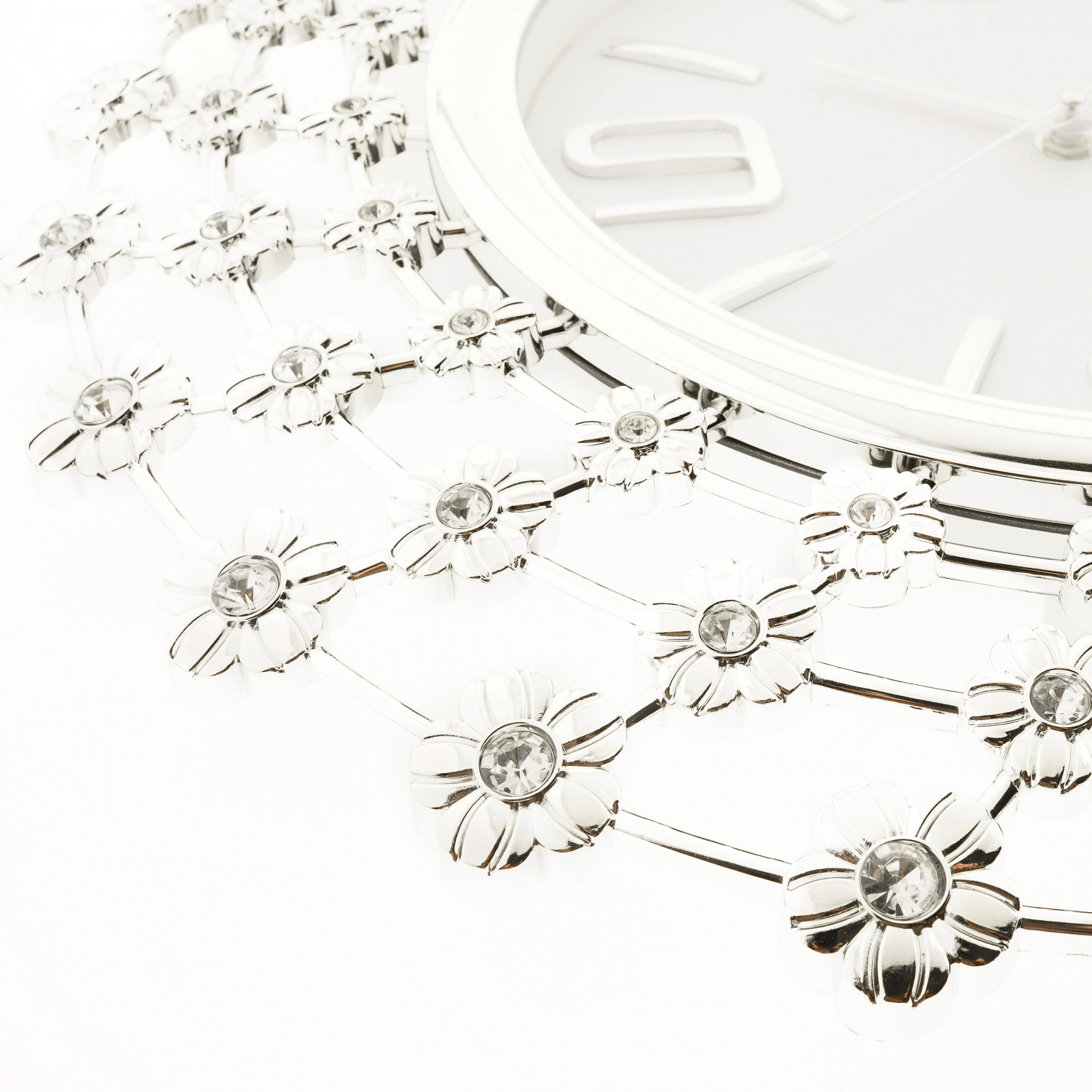 Nahaufnahme einer weißen Wanduhr mit silbernem Blumendesign und römischen Ziffern.
