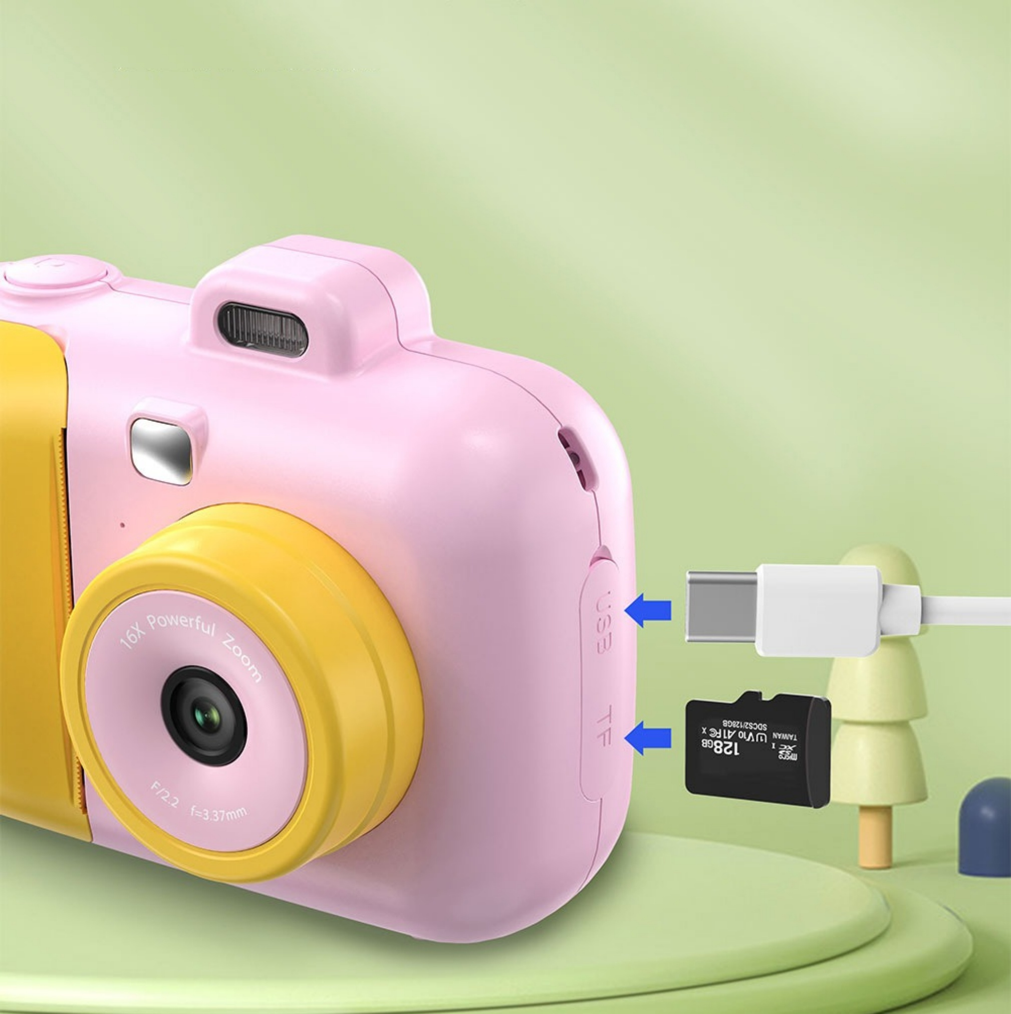 Rosa und gelbe Kinderkamera mit Objektiv, Knöpfen und einem USB-C-Kabel.