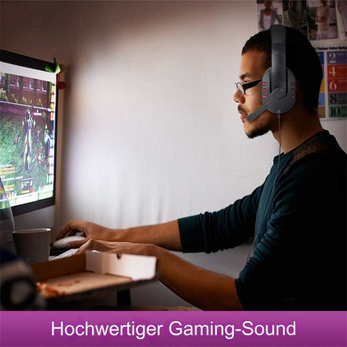 Ein Mann mit Kopfhörern, der ein Spiel auf einem Computer spielt.