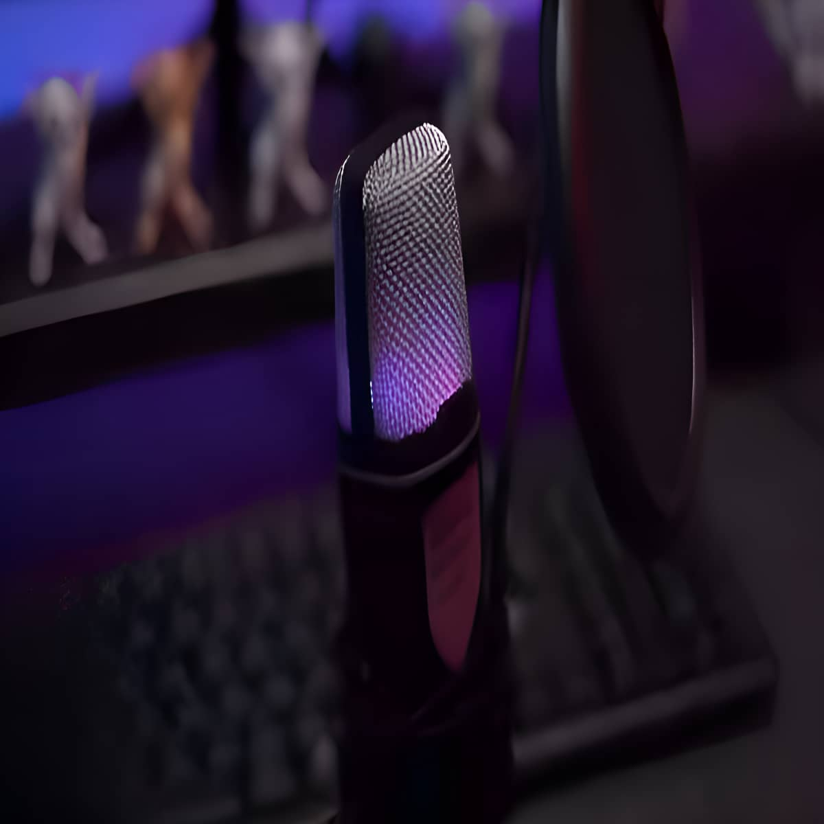 Ein Mikrofon mit Pop-Filter vor einem Computerbildschirm und einer Tastatur.