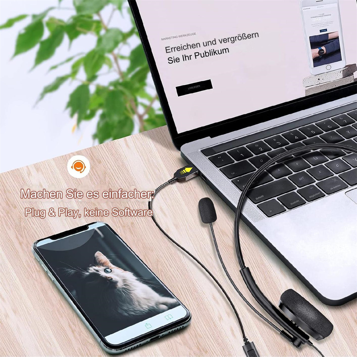 Laptop mit Headset und Smartphone mit Katzenfoto auf einem Holzschreibtisch.