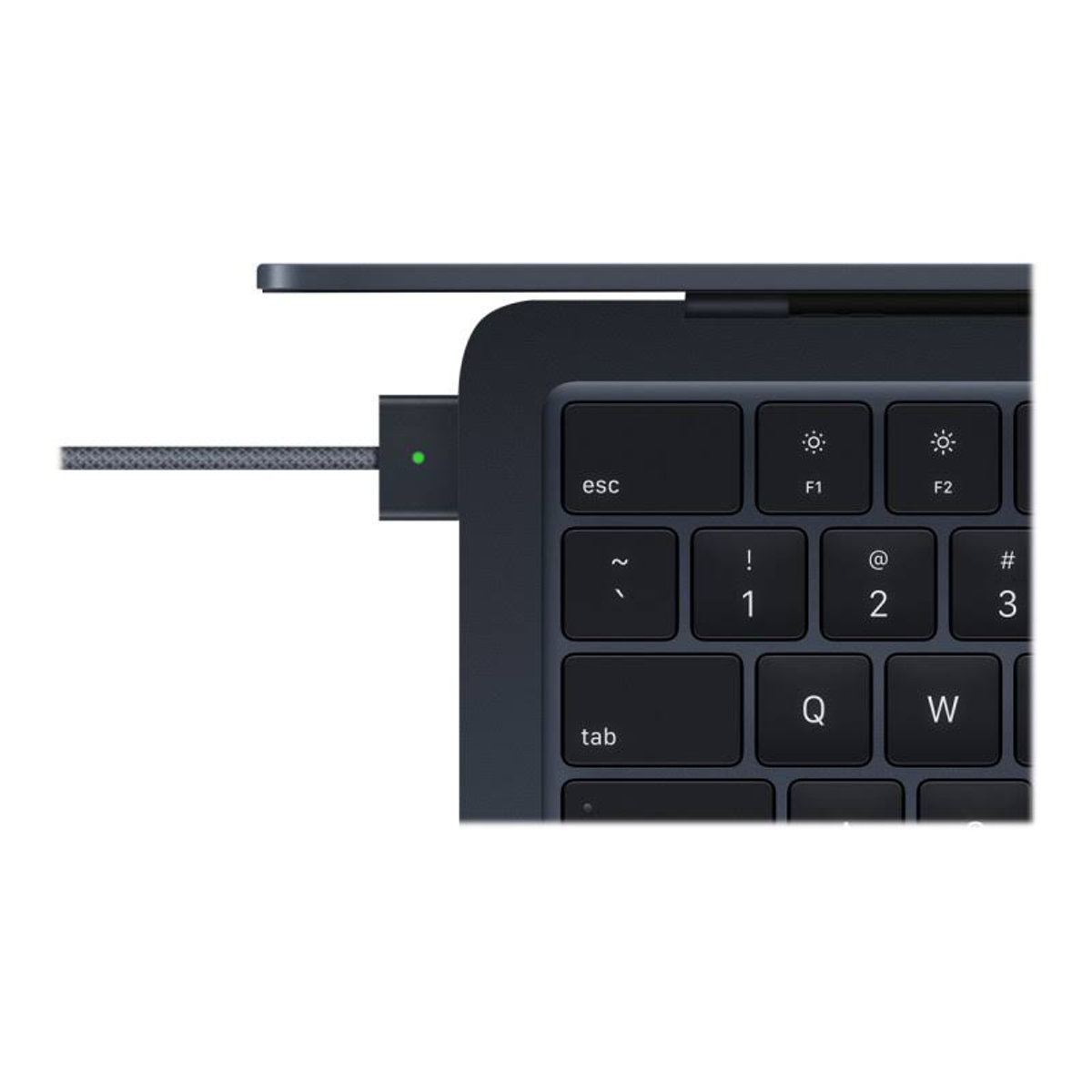 Szczegół laptopa z portem ładowania i zielonym światłem. Widoczna klawiatura.