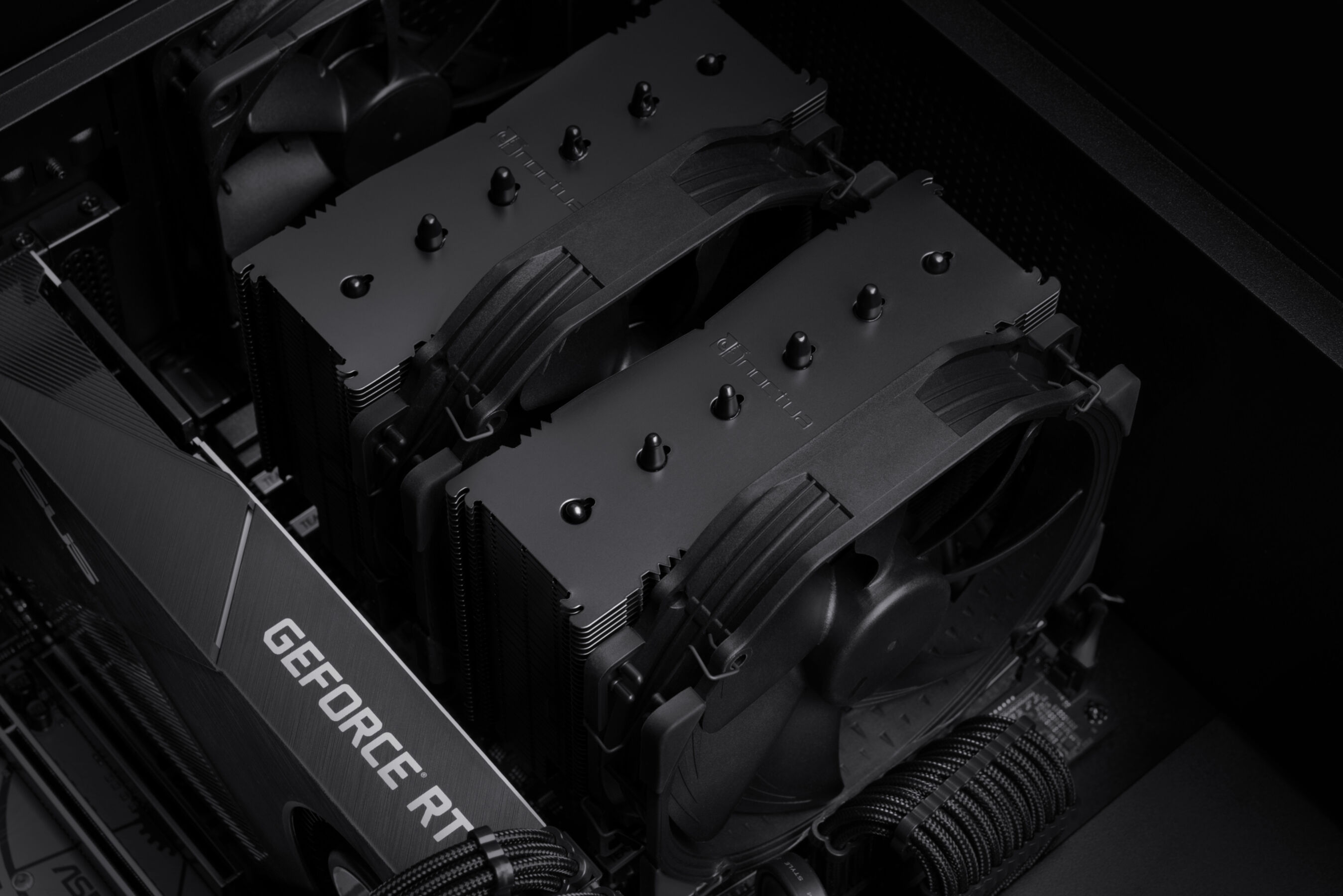 Dwa czarne chłodzenia CPU są zainstalowane w obudowie komputera z kartą GeForce RTX.