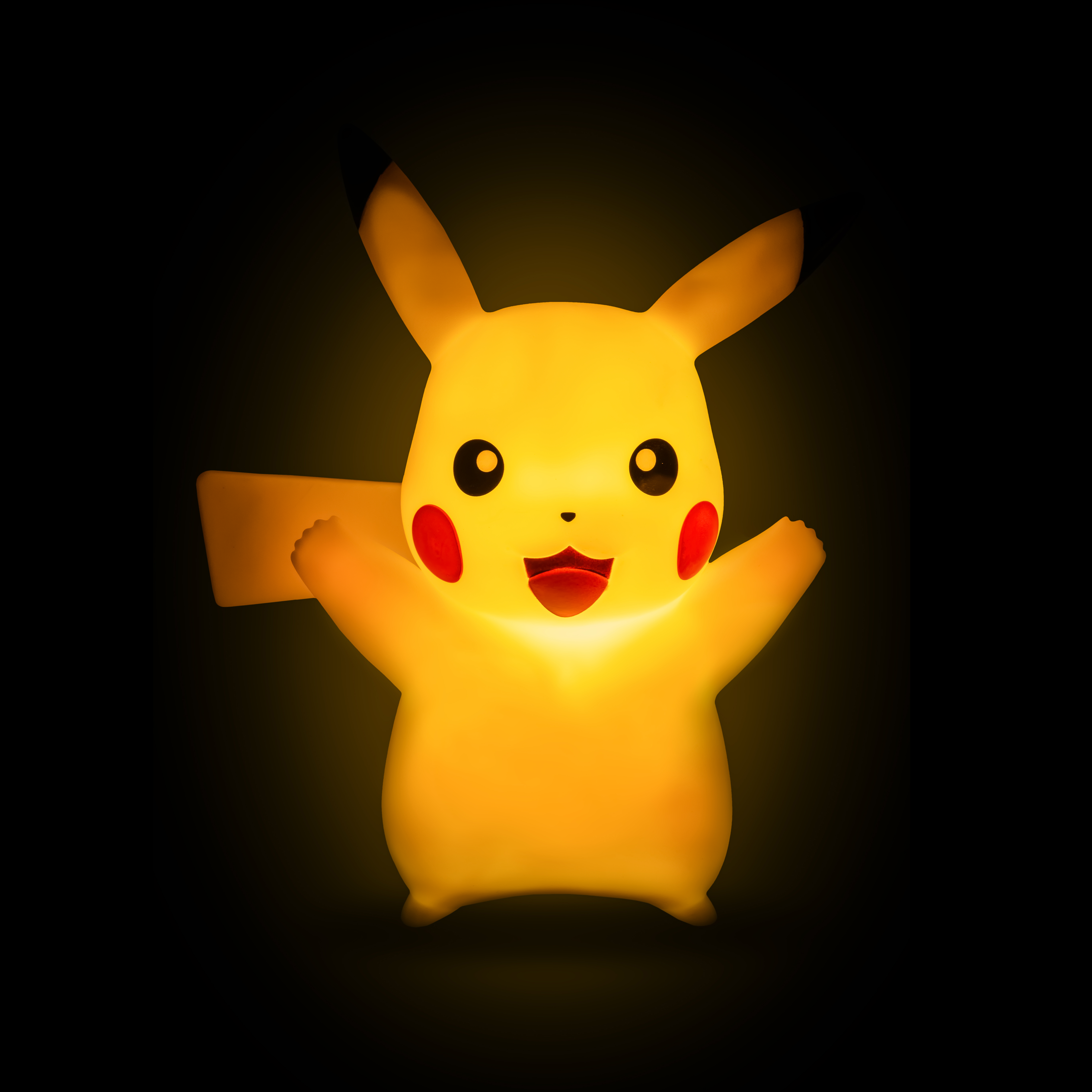 Una lampada di Pikachu con un volto sorridente, illuminata su sfondo nero.