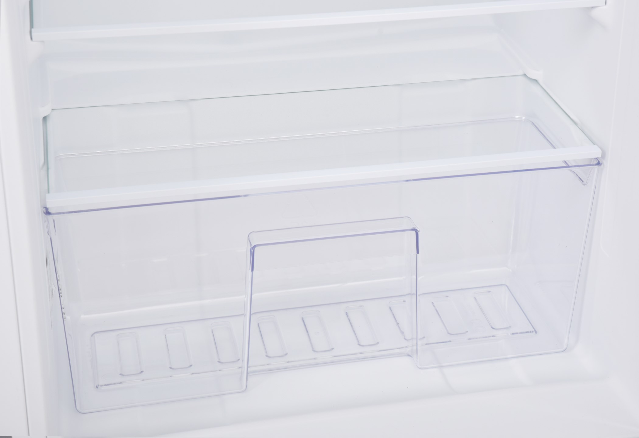 Clear, empty refrigerator drawer with transparent plastic. Inside the refrigerator.