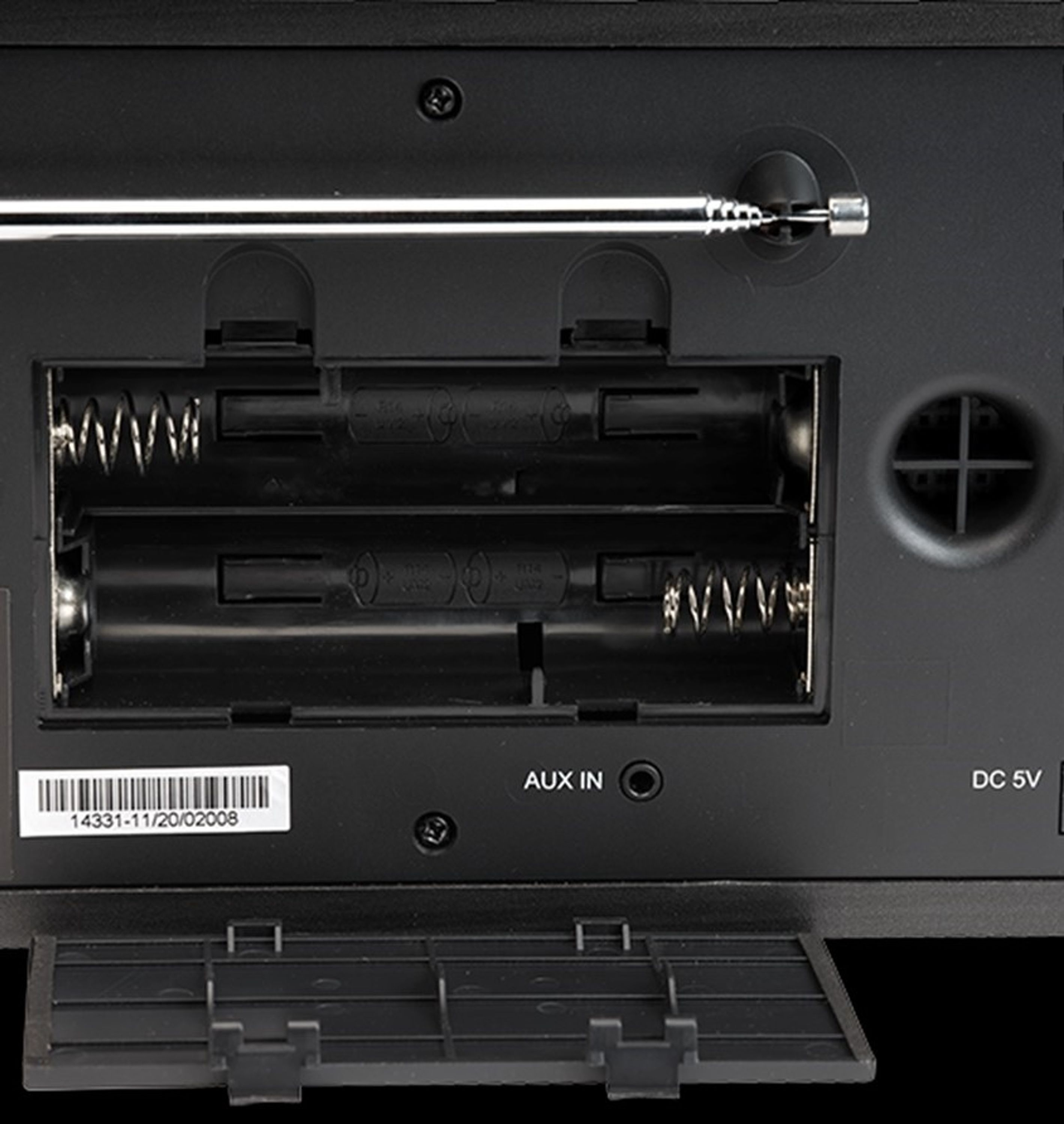 Die Rückseite eines schwarzen Radios mit Batteriefach, Aux-Eingang und DC 5V-Eingang.