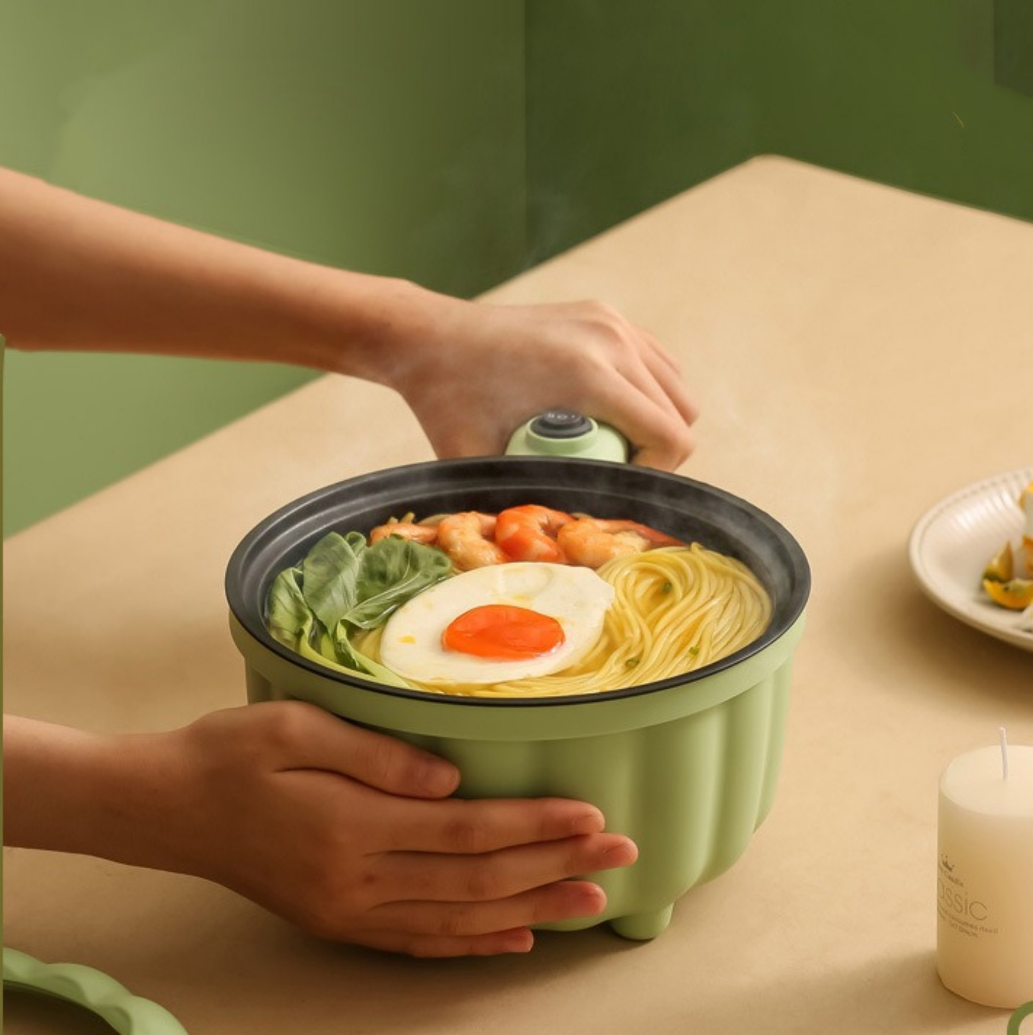 Grüner Topf mit Nudeln, Ei, Garnelen. Hände halten den Topf. Tisch. Teller mit Essen.
