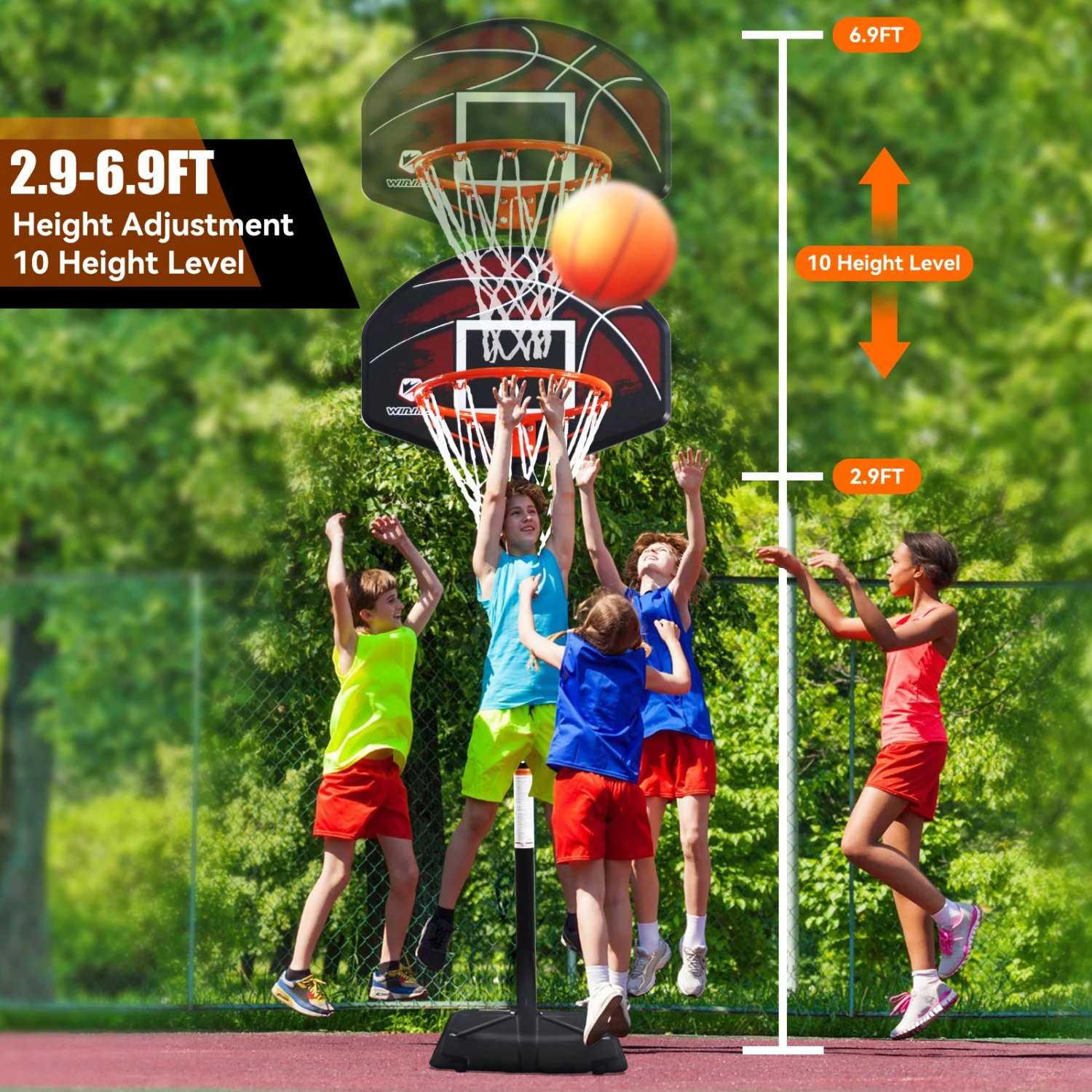Kinder spielen Basketball auf einem Platz mit Basketballkorb und Höhenverstellung.
