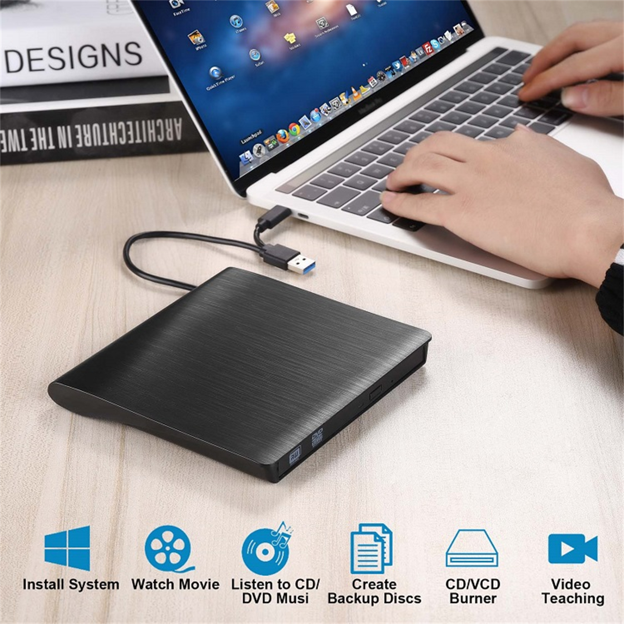 Schwarzer DVD-Brenner neben einem Laptop mit Zubehör.