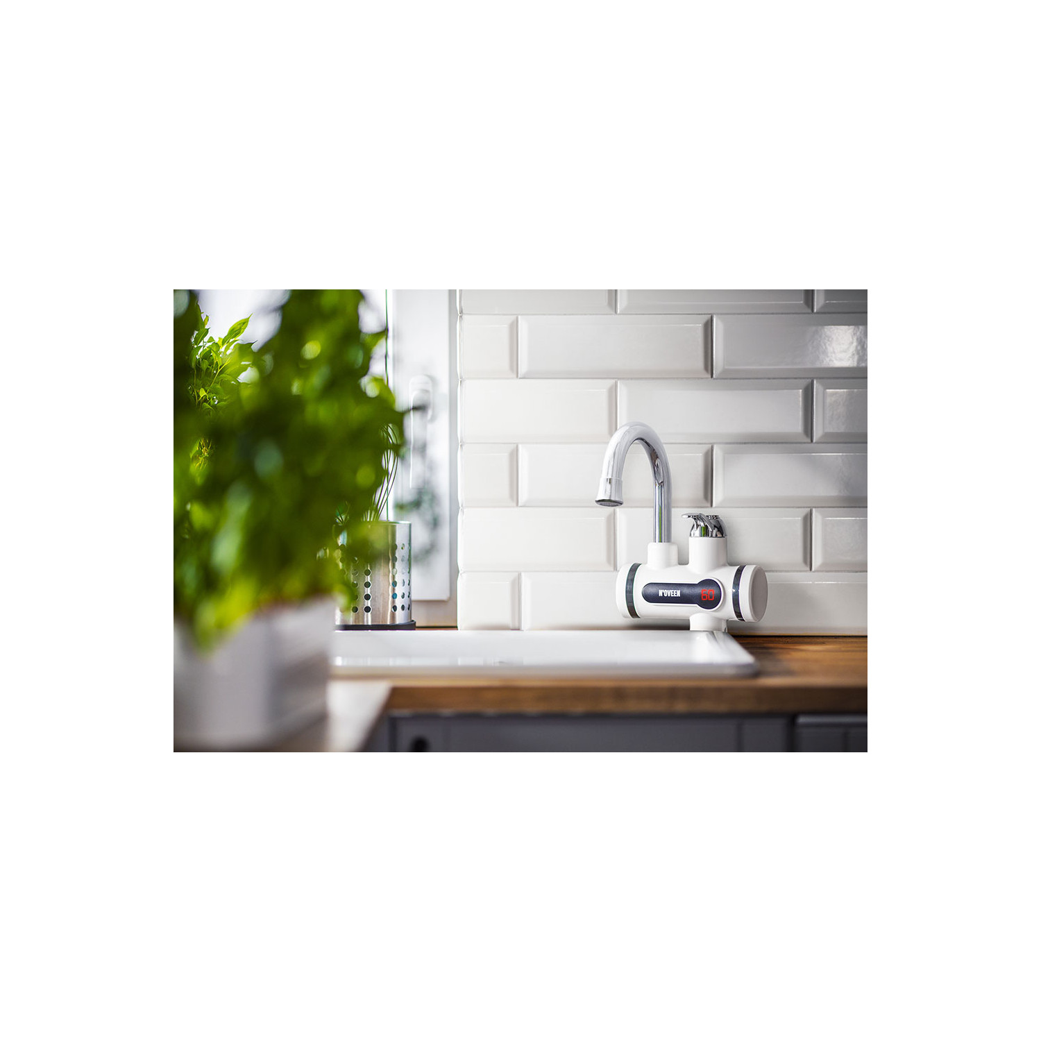 Nowoczesna bateria kuchenna z cyfrowym wyświetlaczem obok rośliny.