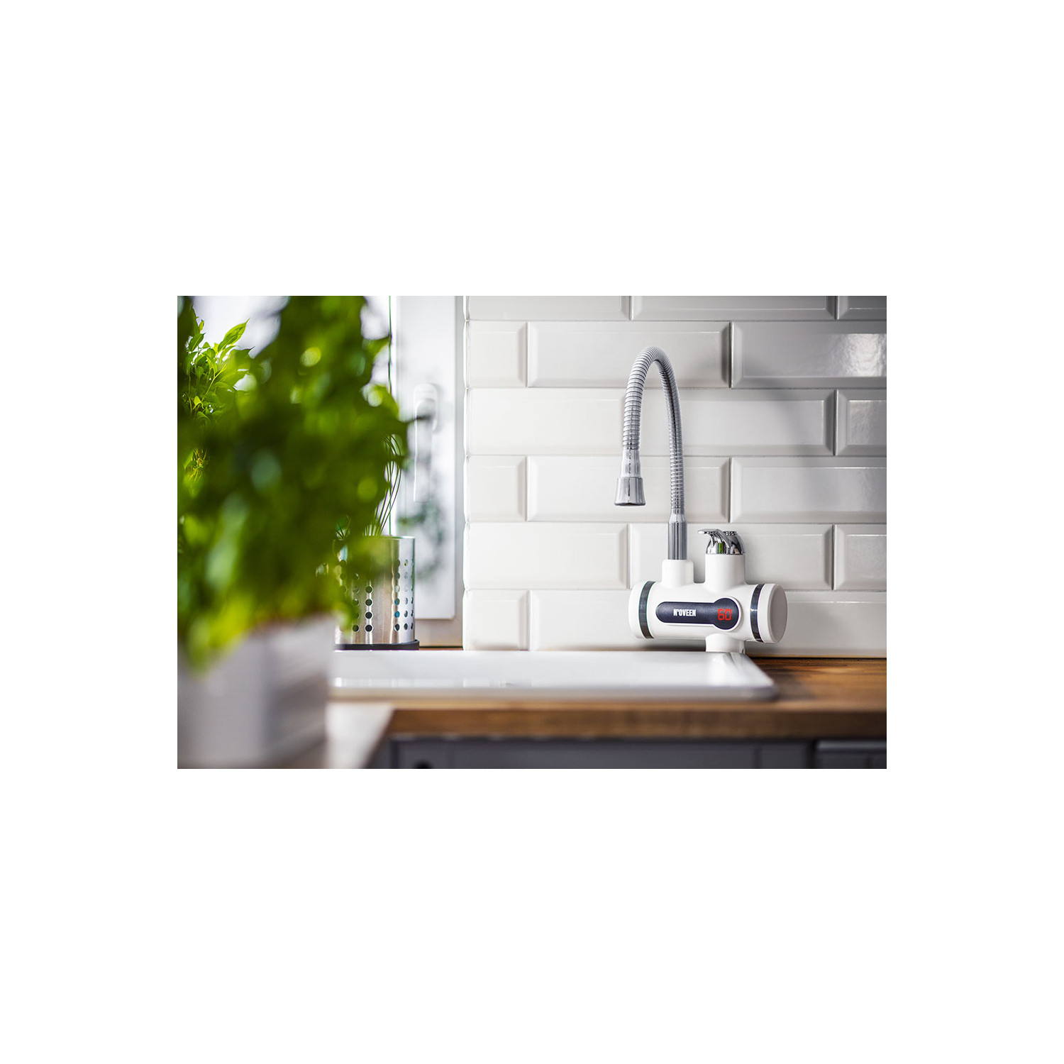 Nowoczesny kran z cyfrowym wyświetlaczem temperatury nad zlewem, na tle białych płytek.