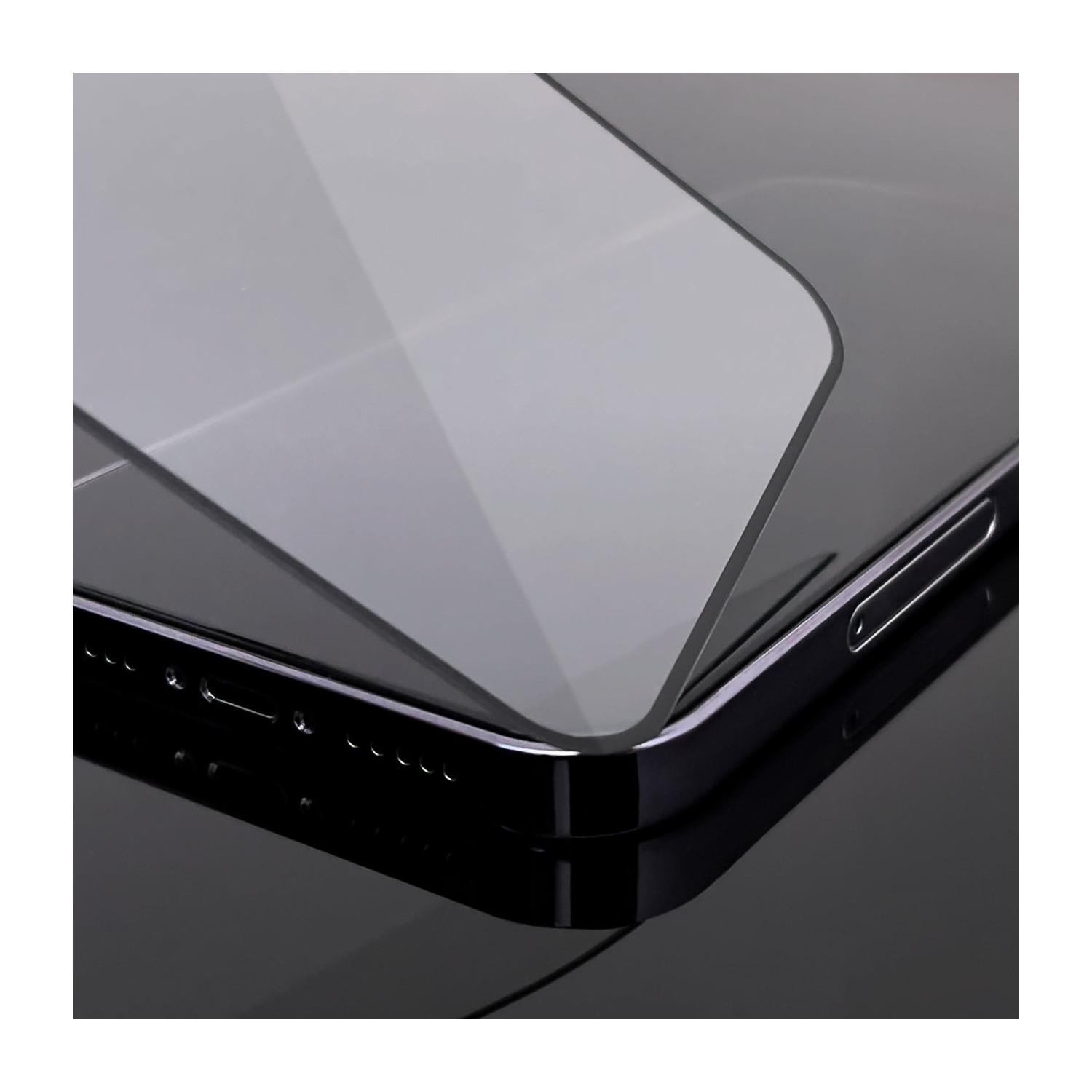 Ein Telefon mit angebrachtem Displayschutz. Das Telefon ist schwarz und liegt auf einer dunklen Oberfläche.