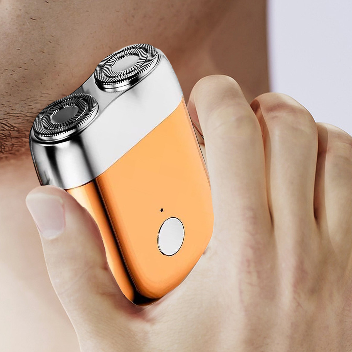 Mann rasiert sich mit einem orangefarbenen und silbernen Elektrorasierer.