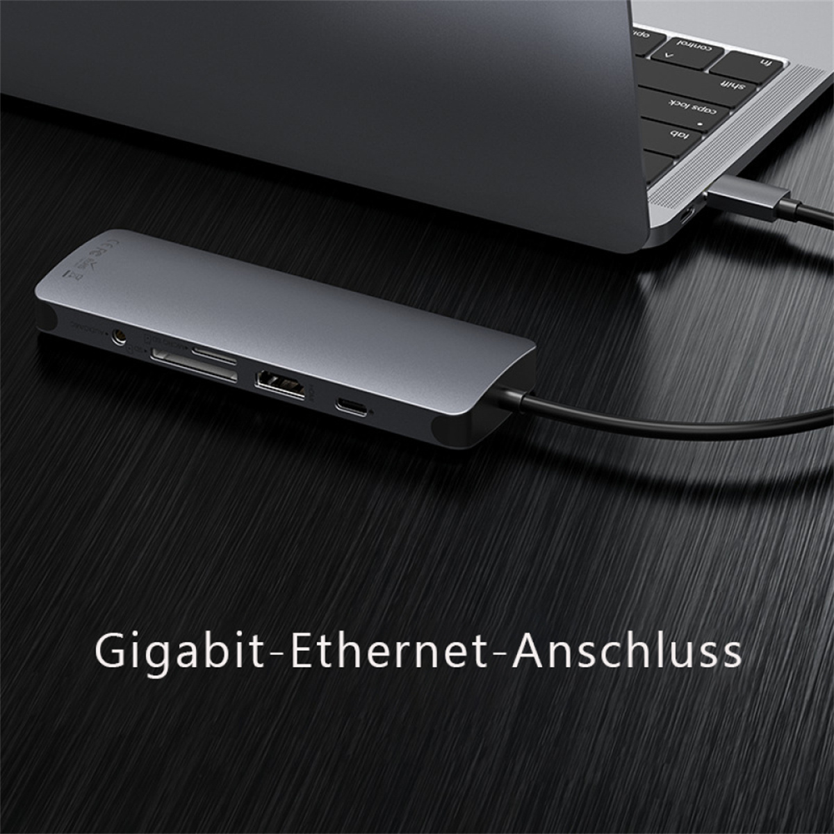 Ein grauer USB-C-Hub mit mehreren Anschlüssen, der an einen Laptop angeschlossen ist.