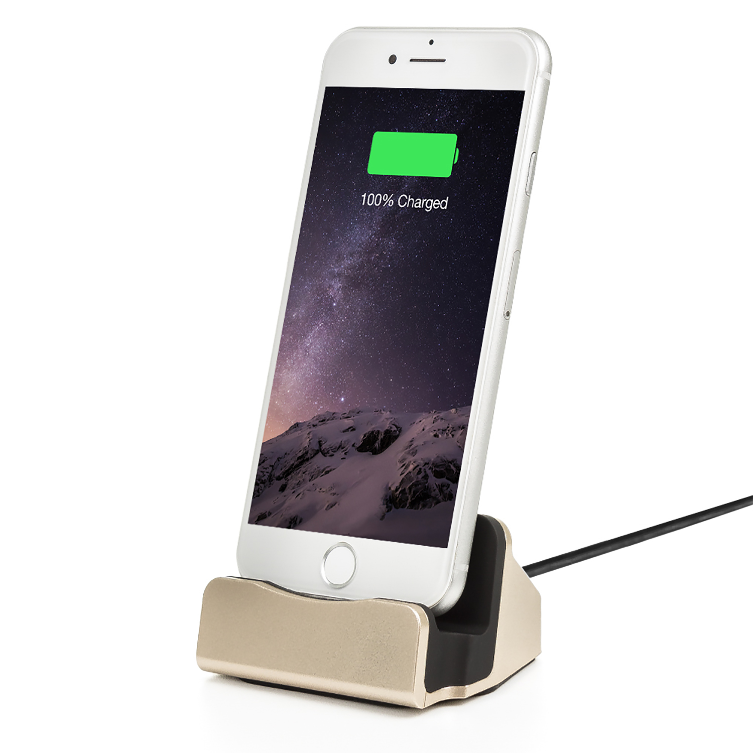 iPhone bianco in una base di ricarica dorata. Lo schermo mostra 100% carica. Cavo nero. Sfondo bianco.