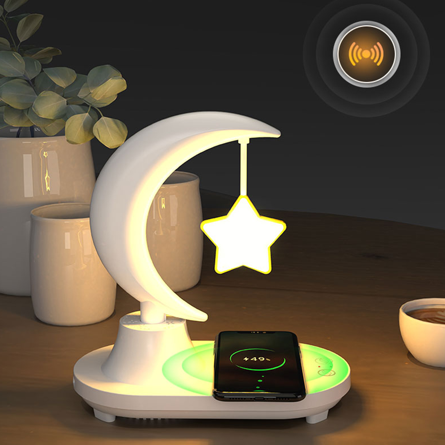Una lampada bianca a forma di luna crescente con una stella. Un telefono su un pad di ricarica si illumina di verde.